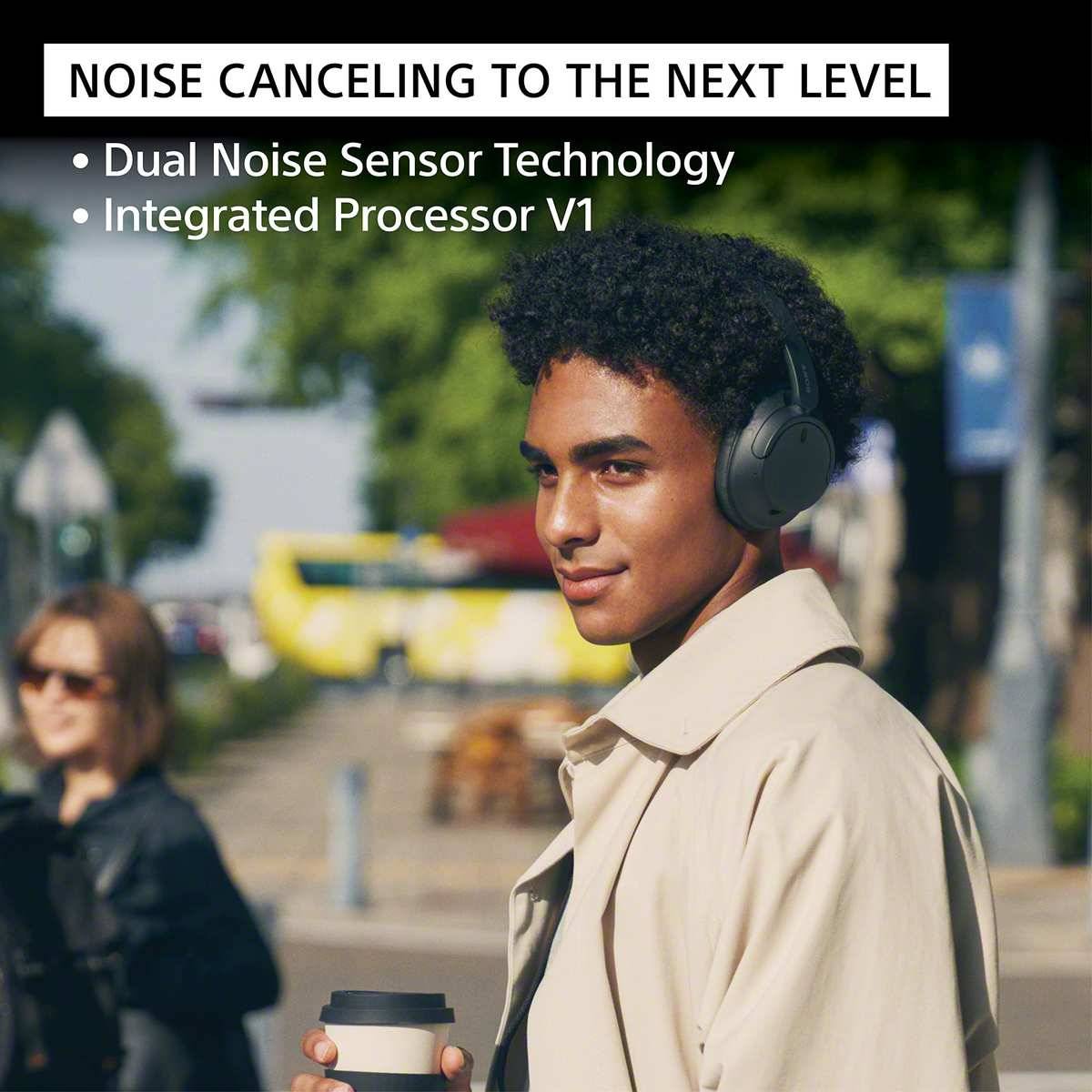 Werbeanzeige mit einem Mann, der draußen Over-Ear-Kopfhörer trägt, der 'NOISE CANCELING AUF DIE NÄCHSTE STUFE' mit 'Dual Noise Sensor Technology' und 'Integrated Processor V1' bewirbt.