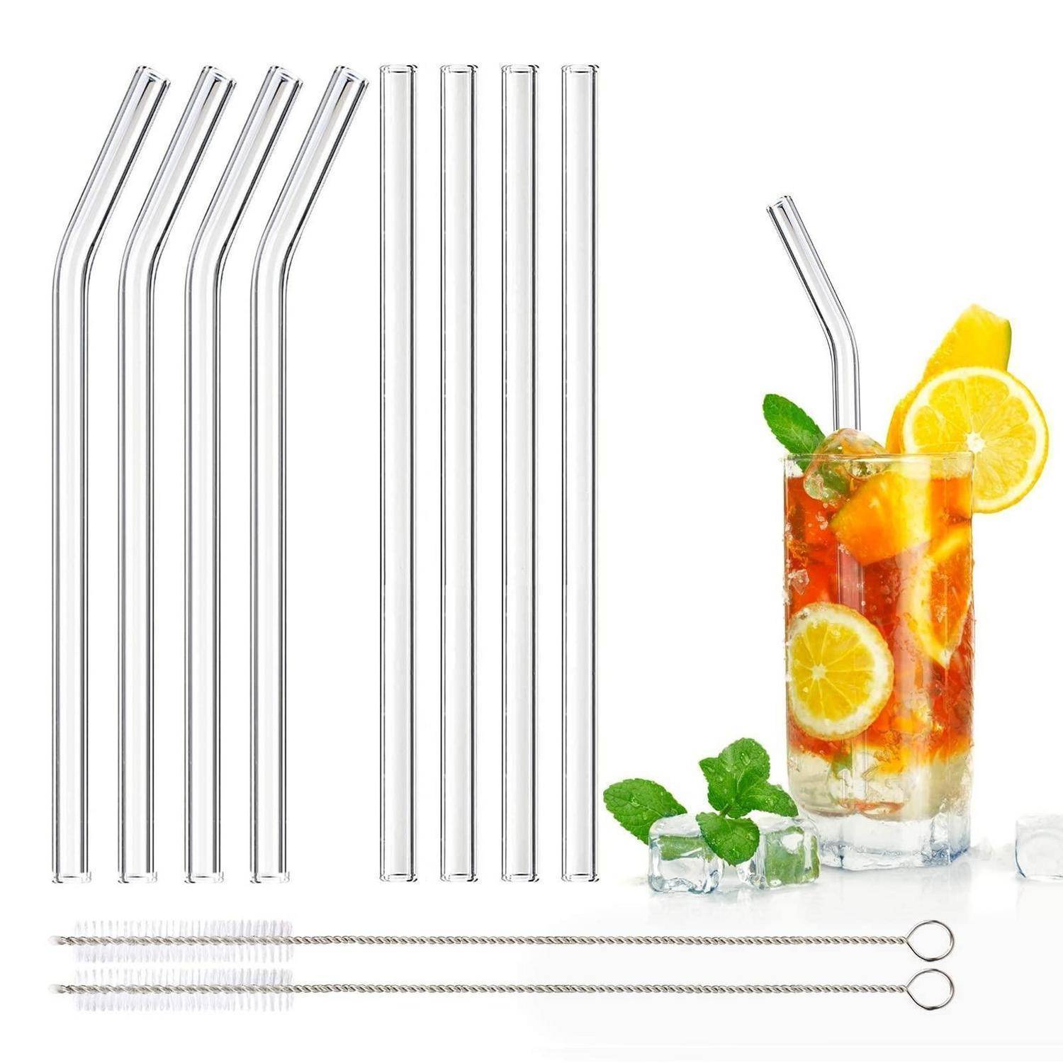 Satz aus wiederverwendbaren Glas-Trinkhalmen mit Reinigern neben einem hohen Eisbechergetränk garniert mit Zitrone und Minze.