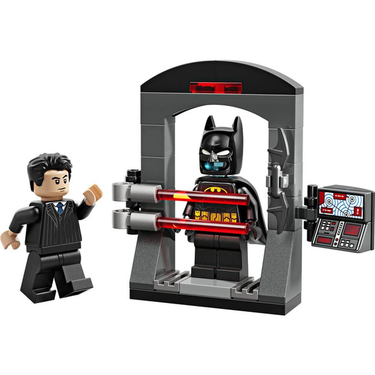 Eine LEGO-Batman-Minifigur steht in einem grauen Scanner-/Containment-Gerät, während eine andere Minifigur neben ihr gestikuliert, mit einem angebrachten Bedienfeld.
