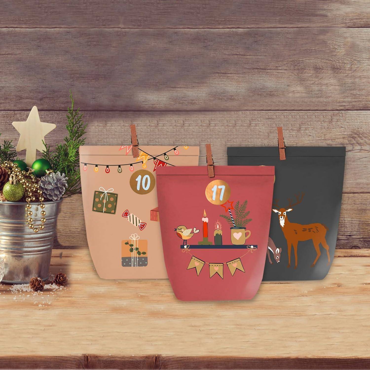 Drei festliche Papiertüten für Adventskalender mit den Aufschriften 10 und 17 stehen auf einem Holzregal neben einer kleinen Weihnachtspflanzendekoration.
