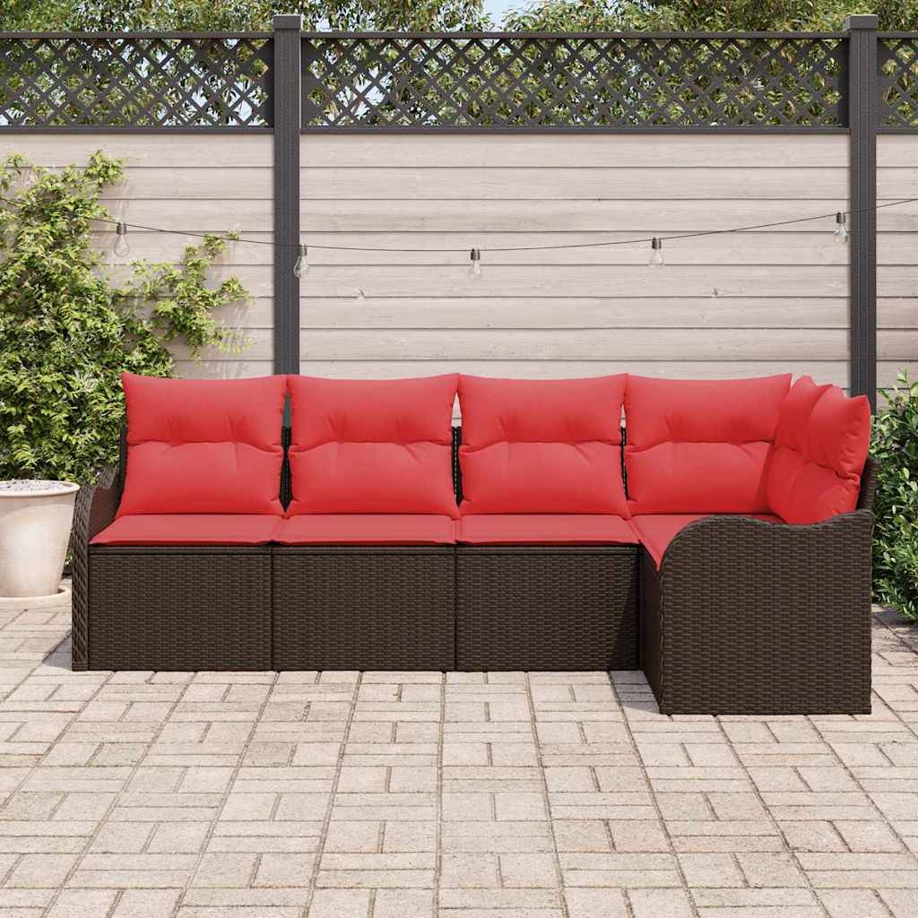 Outdoor-Lounge-Möbelgruppe mit dunklem Rattangeflecht und roten Kissen vor einem Zaun, auf einer gepflasterten Terrasse.