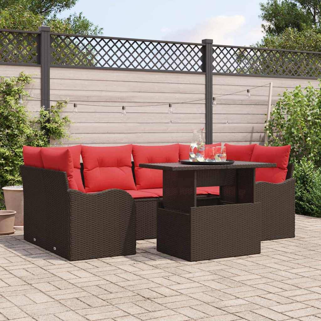 Outdoor-Sitzgarnitur für Terrasse mit roten Kissen um einen dunkelbraun geflochtenen Tisch auf einer gepflasterten Hoftererasse.