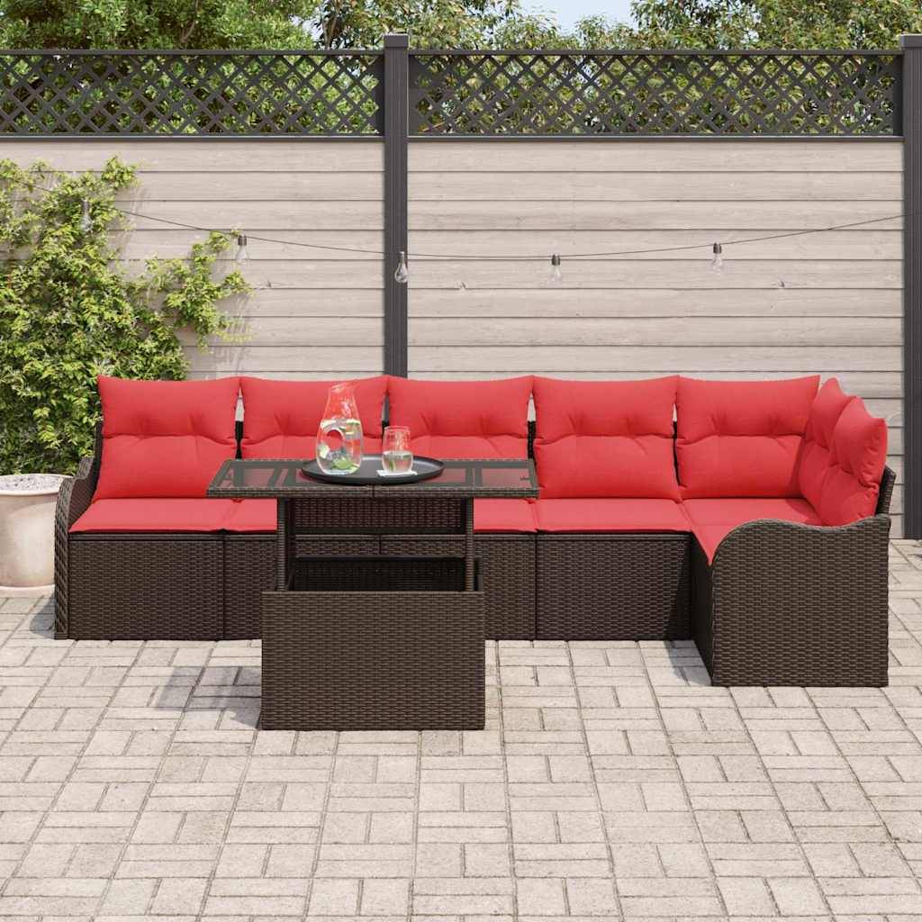 Gartensektional-Sofa mit roten Kissen und einem Glastisch auf einer gepflasterten Terrasse vor einem Sichtschutzgitter.