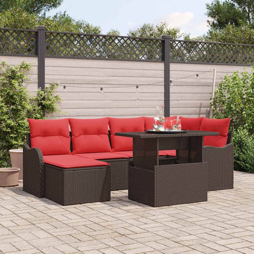 Gartenmöbel-Set für die Terrasse mit roten Polstern und dunkelm Rattantisch auf einer gepflasterten Hinterhofrasse, mit Zaun und Grünflächen im Hintergrund.