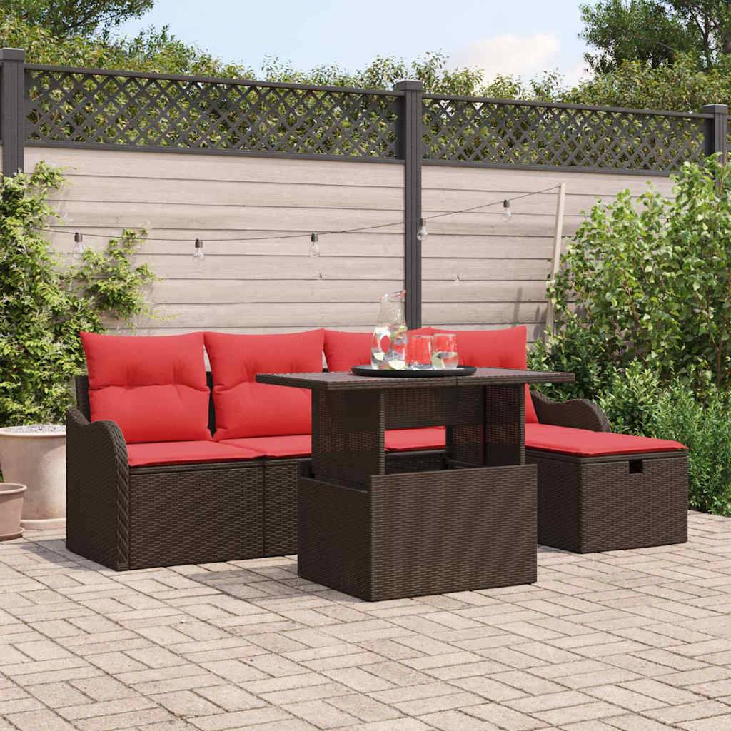 Gartensitzgruppe auf einer gepflasterten Gartenterrasse mit braunem geflochtenem Sofa, roten Kissen, Ottomane und Tisch mit Getränken.