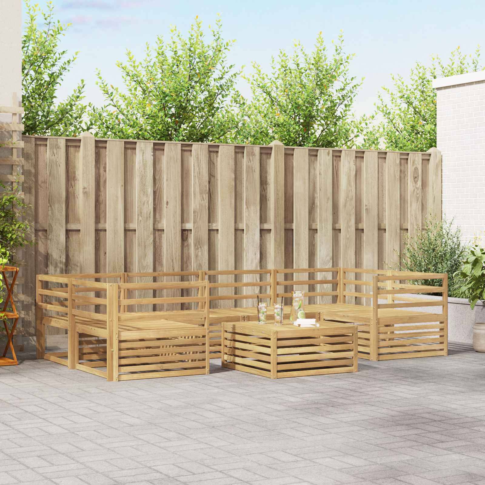 Holzige Outdoor-Ecksofa mit Couchtisch auf einer Terrasse, vor einem hohen Zaun und Bäumen aufgestellt, mit einer kleinen Topfpflanze in der Nähe.