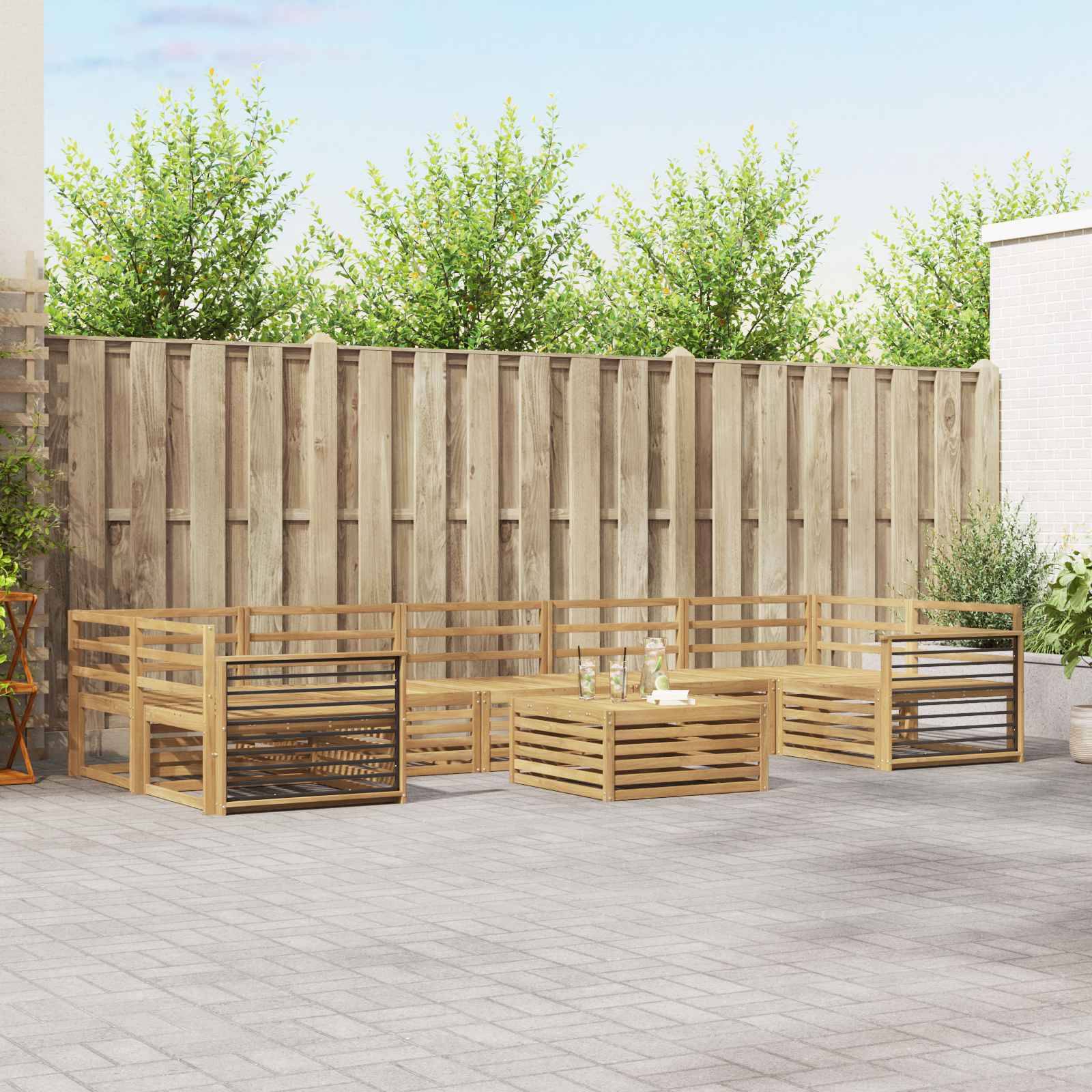 Outdoor-Terrasse mit niedrigen Holzlatten-Sitzelementen in Sectional-Form um einen zentralen Couchtisch auf einer gepflasterten Terrasse neben einem hohen Zaun und Bäumen.