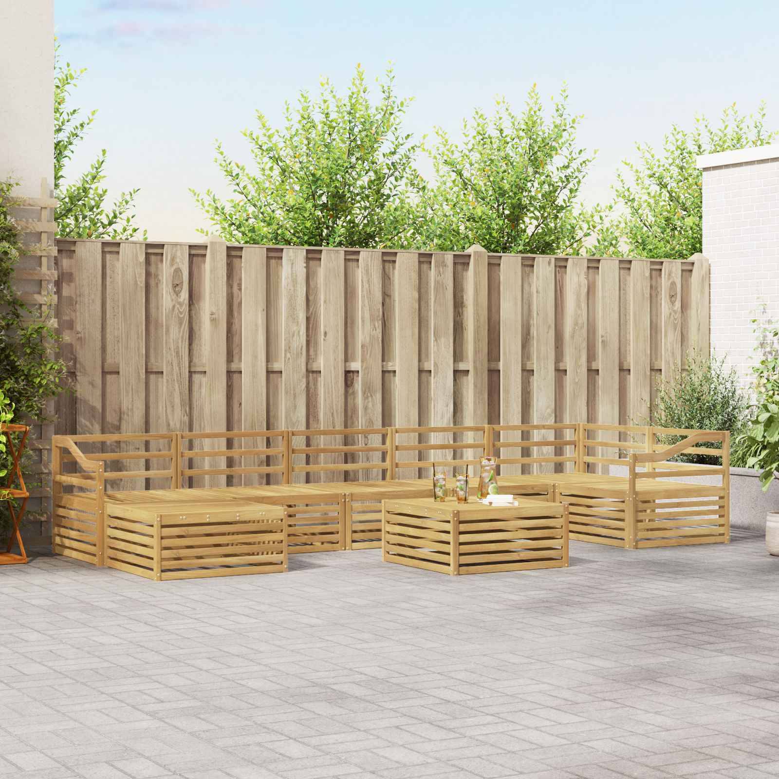 Holz-Außensektionalsofa mit Lamellenkaffeetisch auf einer gepflasterten Terrasse neben einem Holzzaun und Grünflächen.