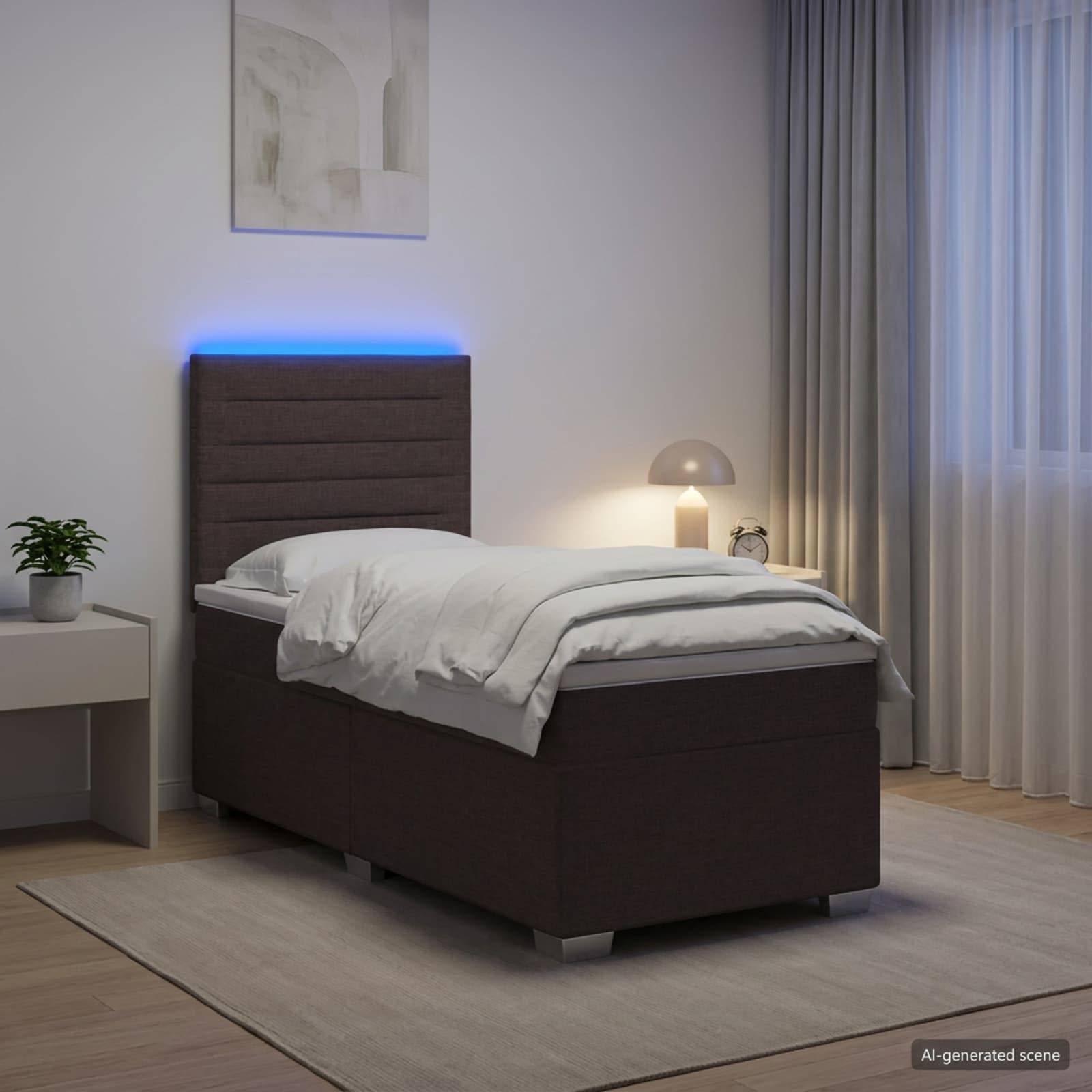 Modernes Schlafzimmer mit einem Einzelbett, blau beleuchteter Kopfleiste, Nachttischlampe, kleinem Tisch und Vorhängen neben einem Fenster.