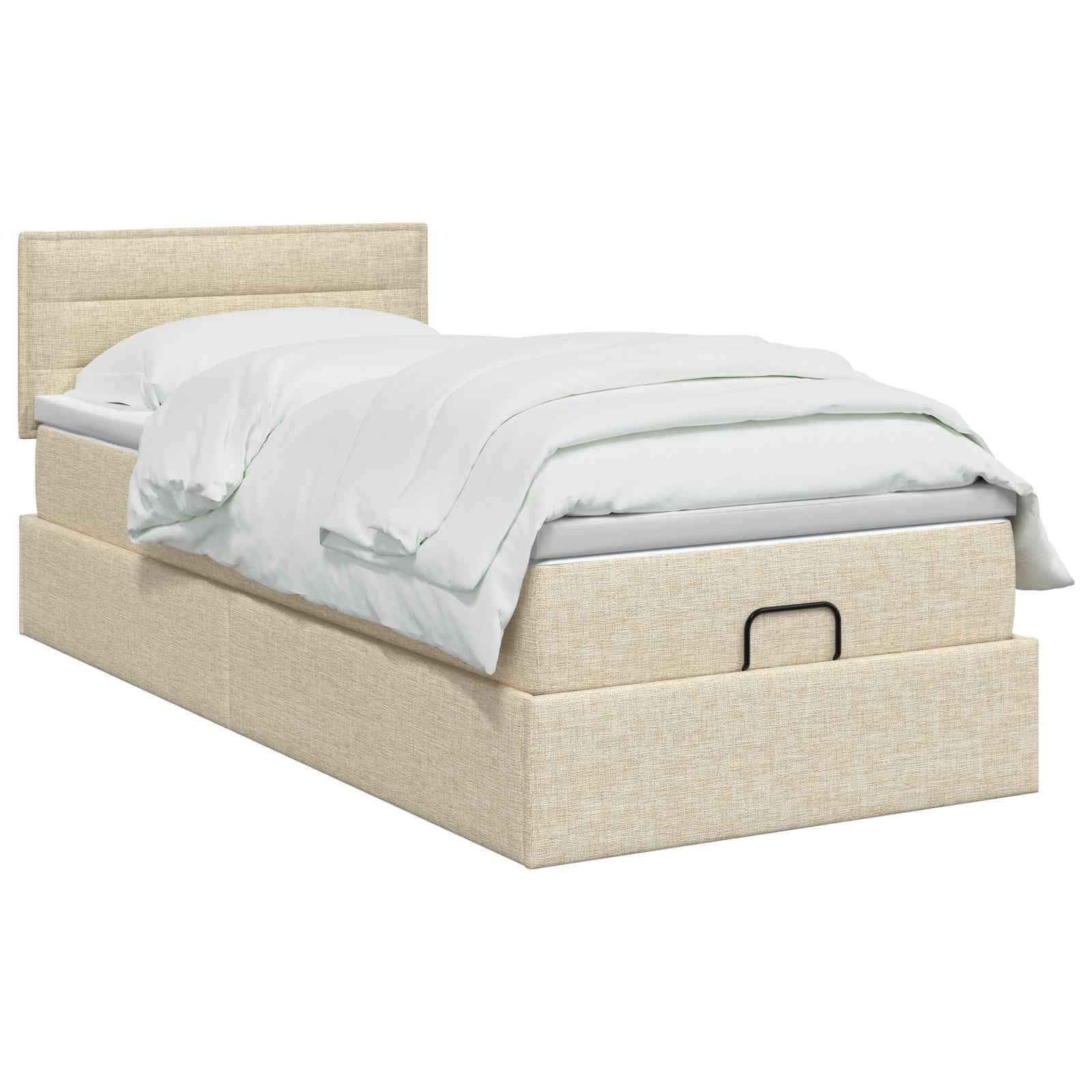 Beiges Polsterbett mit Kopfteil und weißer Bettwäsche, wobei eine Schublade unter dem Bett sichtbar ist.