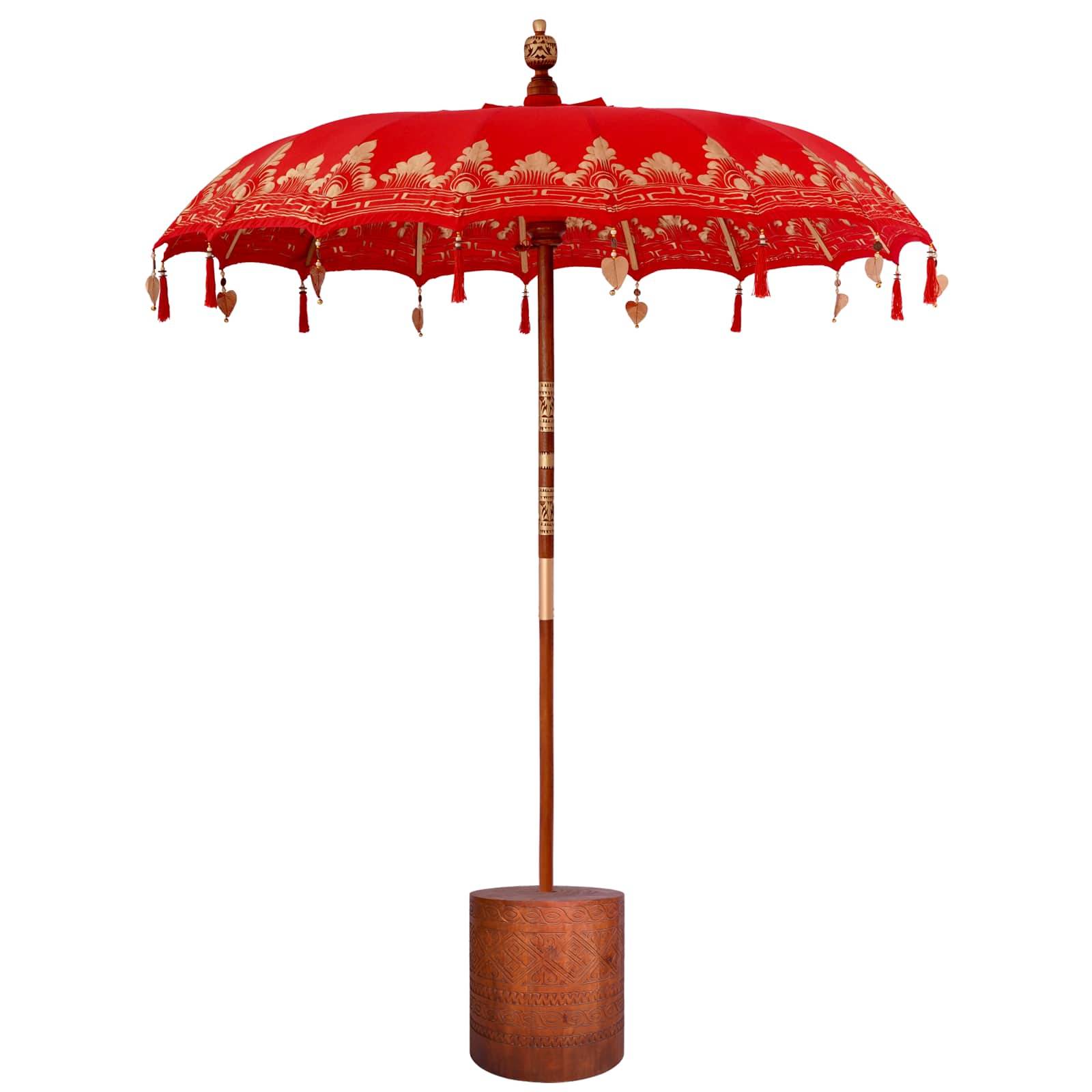 Roter dekorativer Sonnenschirm mit goldenem Blumenmuster und Quasten, montiert auf einem Holzstab mit zylindrischer Basis, freigestellt auf weißem Hintergrund.