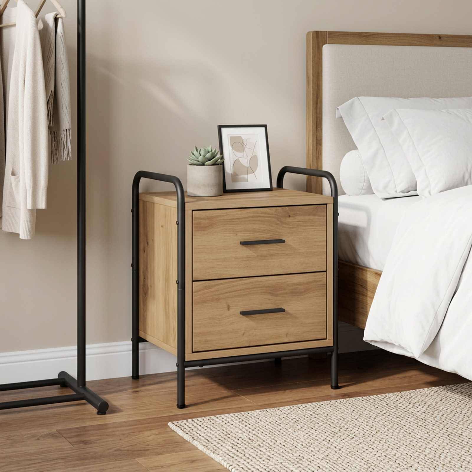Modernes Schlafzimmer mit einem Holznachttisch neben einem Bett, auf dem eine kleine Pflanze und ein gerahmtes Kunstwerk stehen, neben einem Kleiderständer.
