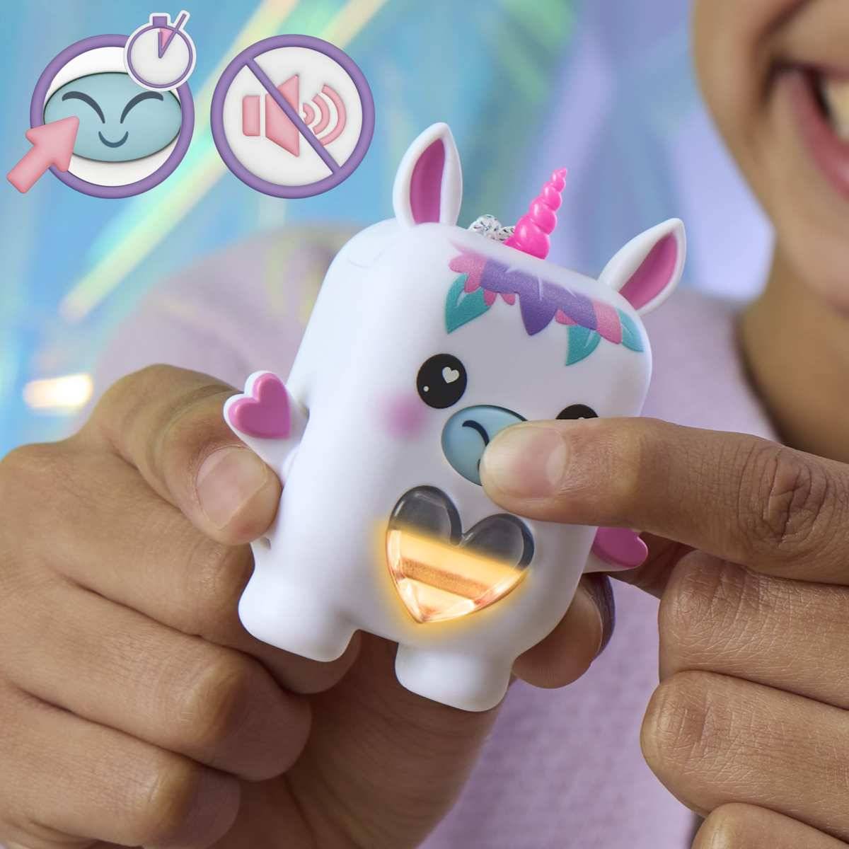 Kind drückt ein Einhorn-Spielzeug, das leuchtet und glüht; Icons zeigen Drückbewegung und Stummschaltung des Tons.
