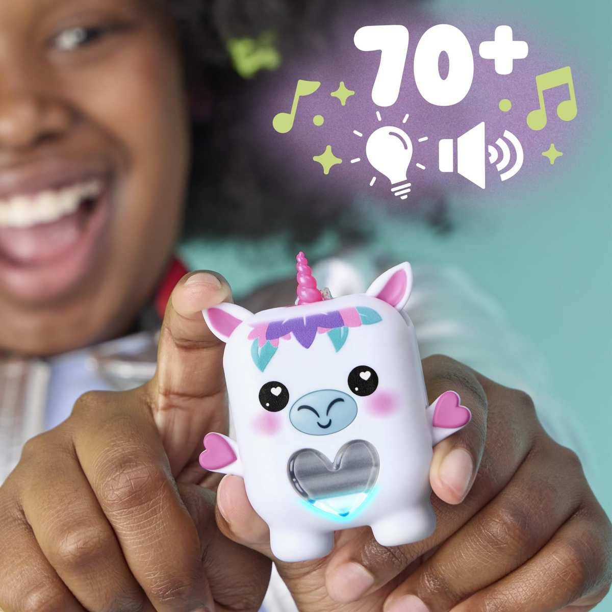 Kind hält ein lächelndes Einhorn-Spielzeug mit Lichtern und Sound; auf dem Bildschirm steht „70+