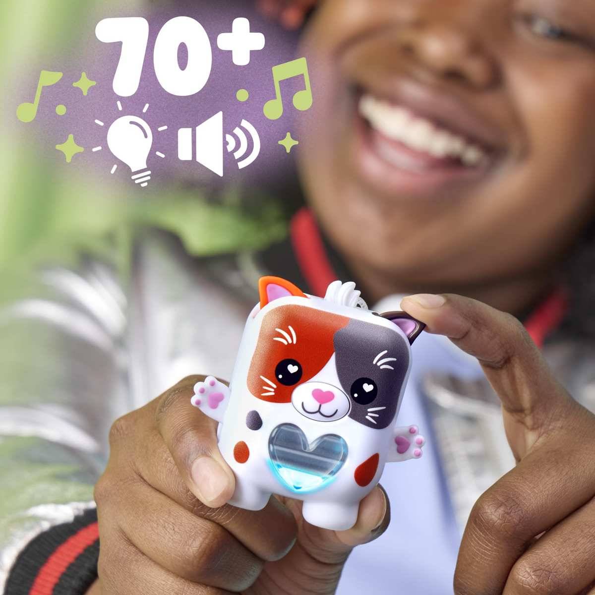 Ein lächelndes Kind hält ein kleines leuchtenden Spielzeug-Haustier mit „70+