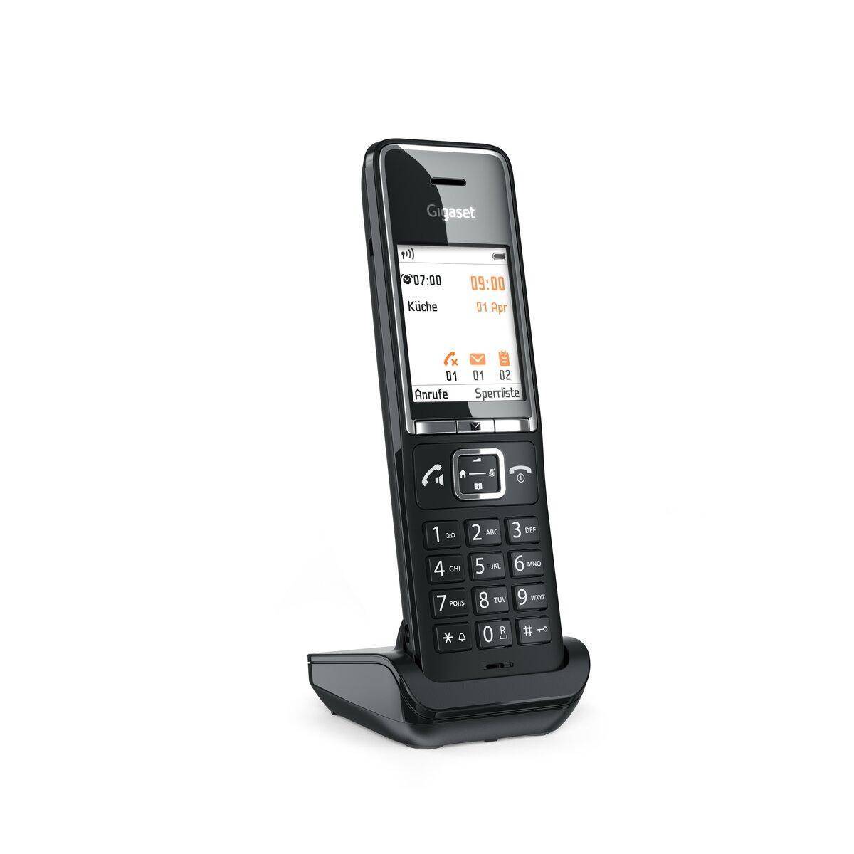 Schwarzes schnurloses Festnetztelefon, das auf einer Ladestation steht, mit beleuchtetes Display und Tastatur.