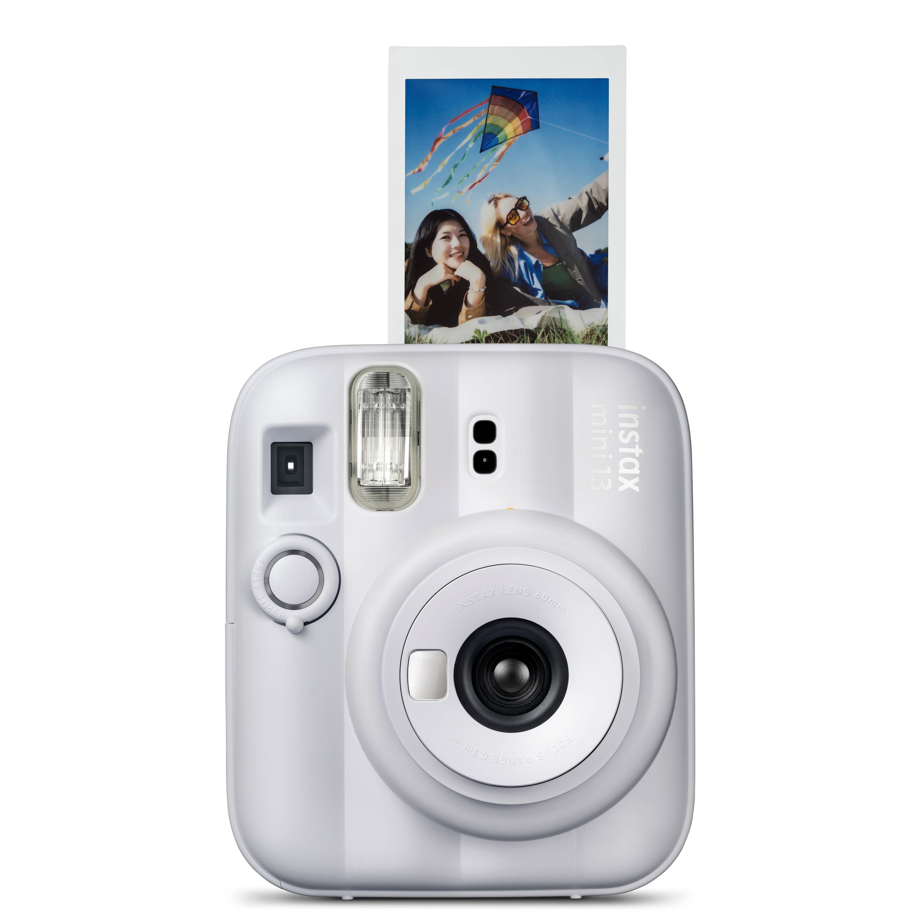 Weiße Fujifilm Instax Sofortbildkamera druckt ein Farbfoto zweier Personen, die einen Drachen gegen einen blauen Himmel fliegen.