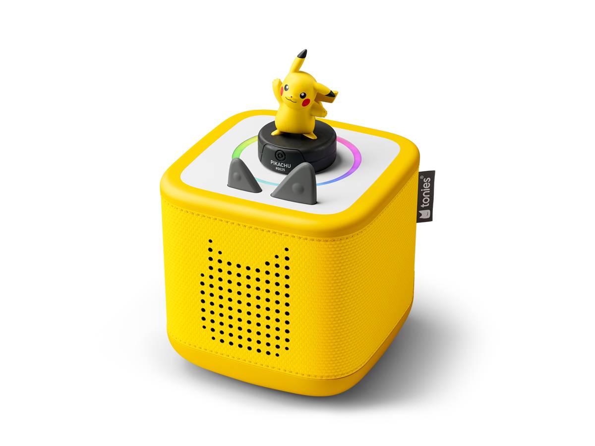 Gelber würfelförmiger Bluetooth-Lautsprecher mit einer Pikachu-Figur oben drauf und einem kleinen Bedienrad, dargestellt vor schwarzem Hintergrund.