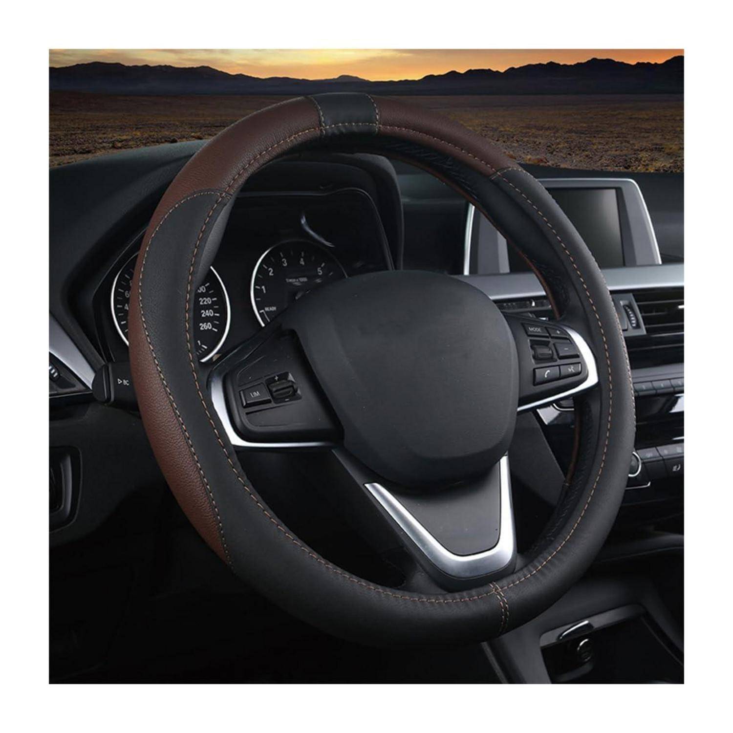 Autoinnenraum mit einem braun-schwarzen Lederlenkrad und Armaturenbrett, gezeigt vor einer Wüstensonnenunte­rgangskulisse durch die Windschutzscheibe.