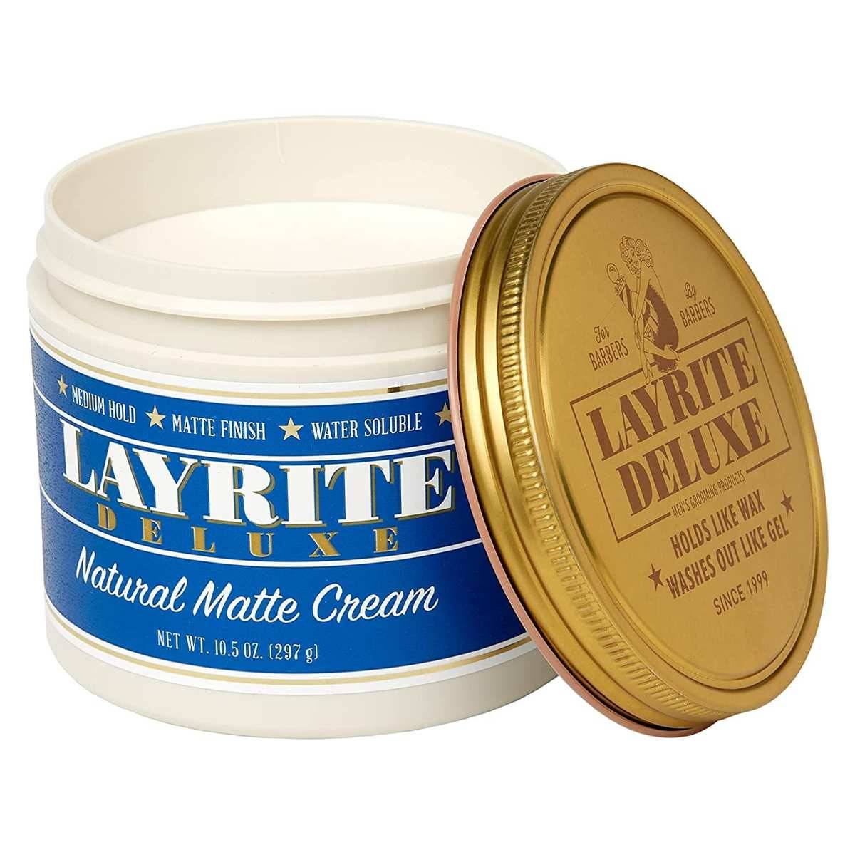 Offener Behälter von Layrite Deluxe Natural Matte Cream Haarstyling-Produkt mit goldenem Deckel daneben.