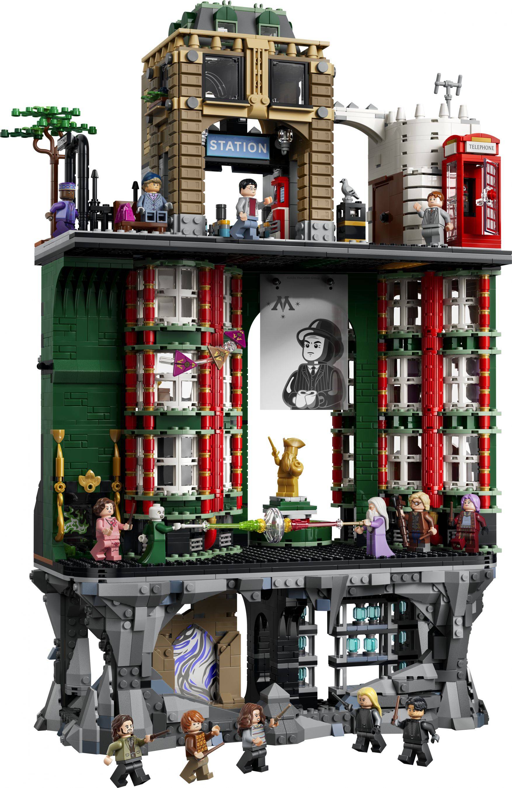 Detaillierte LEGO-ähnliche modulare Gebäudeausstellung mit einem "STATION""-Schild, rote Telefonzelle, Minifiguren und eine untere felsige Untergrundebene mit versteckten Räumen und Figuren.