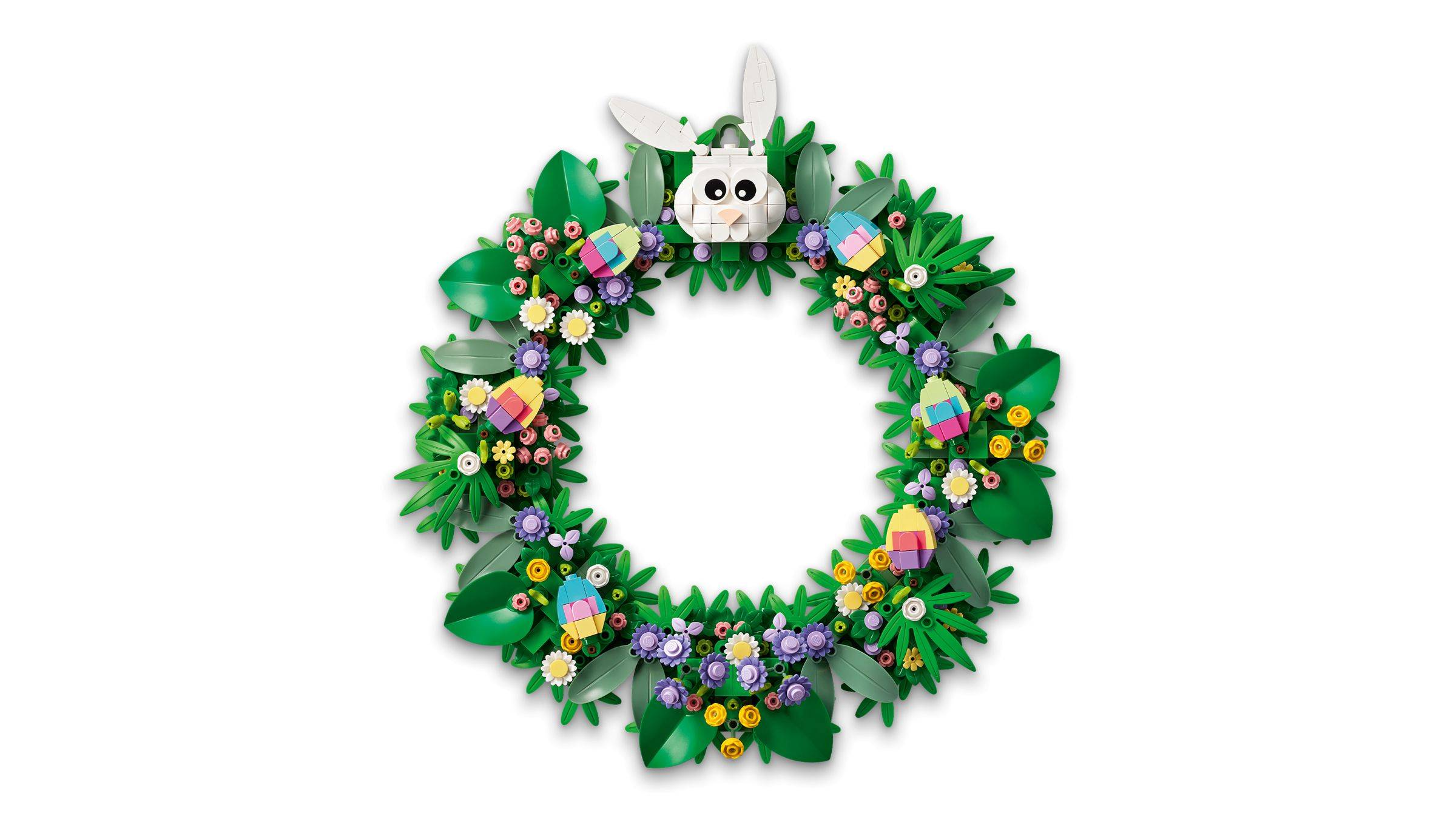 Ein dekoratives Oster-Gesteck mit einem weißen Hasengicht an der Spitze, umgeben von grünen Blättern, Pastellblüten und farbigen Eiern auf weißem Hintergrund.