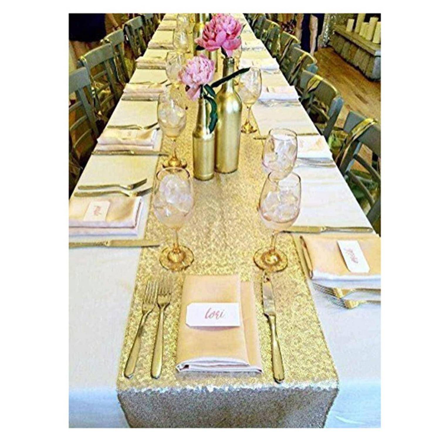Eleganter Bankettisch mit goldenem Tischläufer, rosa Blumen in Vasen, Weingläsern und Platzkarten mit der Aufschrift „Liebe" an jedem Gedeck.