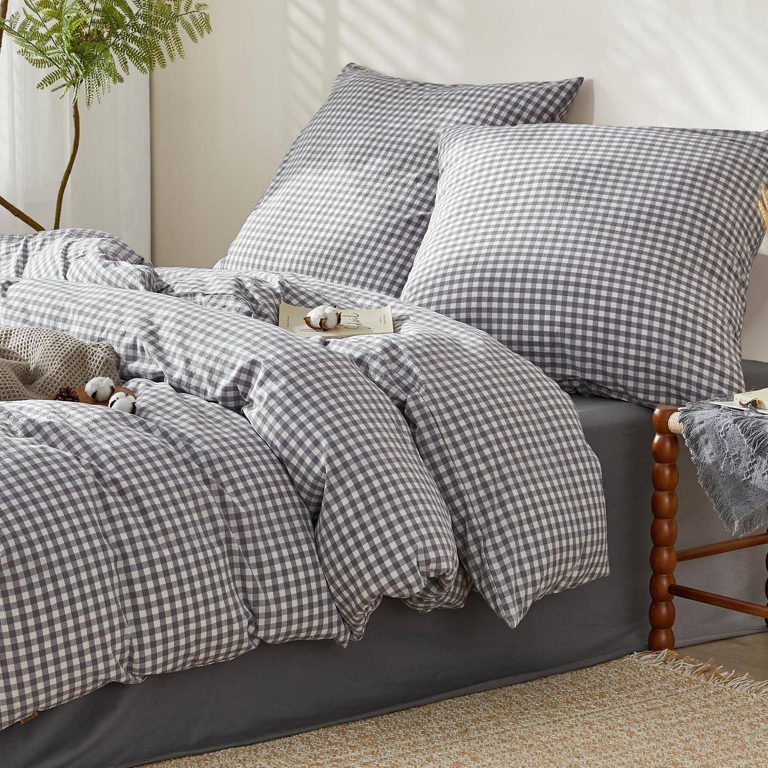 Bett mit grauem Gingham-Steppdecke und Kissen, gestylt mit einer gemütlichen Decke und Deko in einem hellen Schlafzimmer.