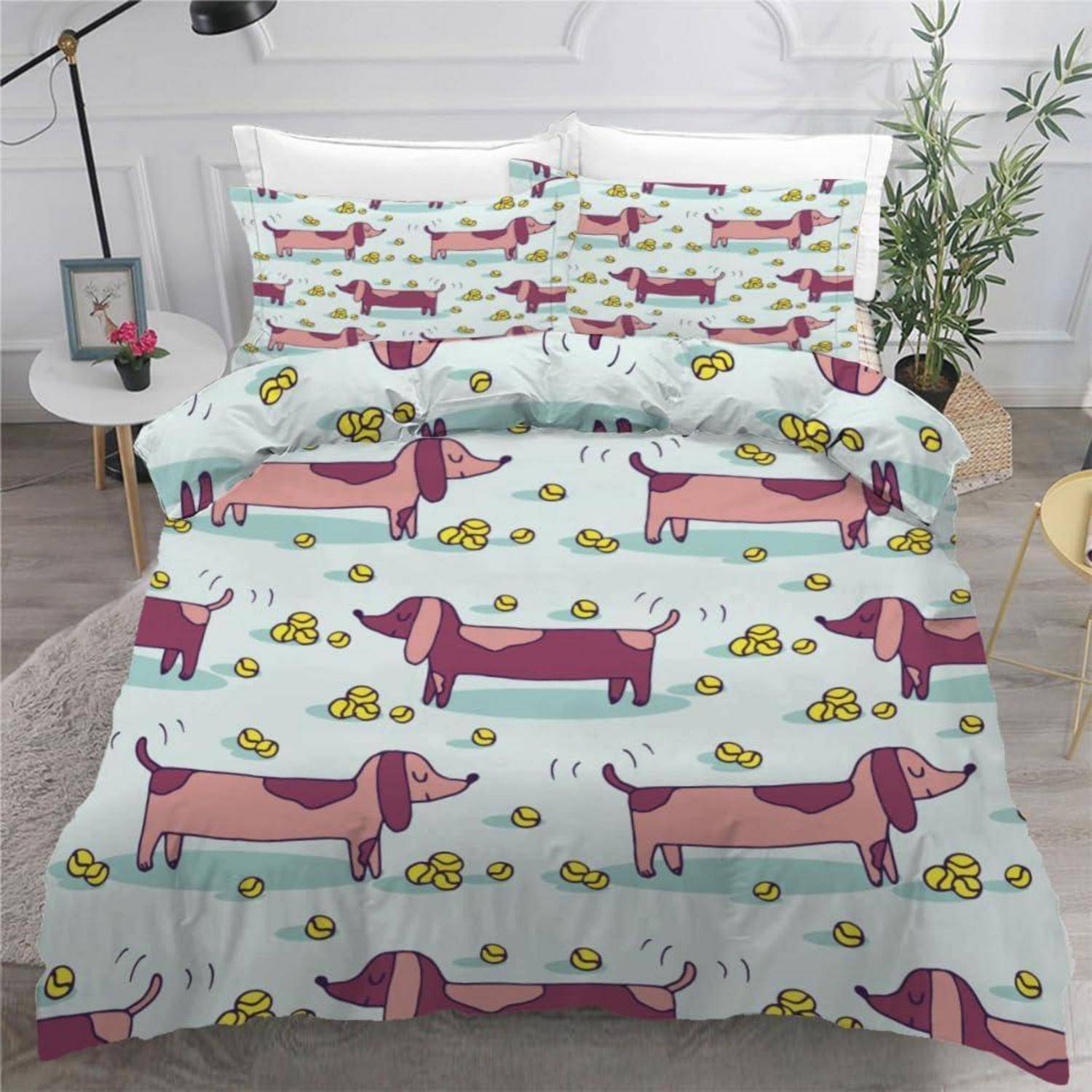 Ein Dackelthemen-Bettwäscheset mit Cartoon-Hunden und gelben Pfotenbdrücken auf hellblauem Hintergrund, ordentlich auf einem Bett ausgebreitet.