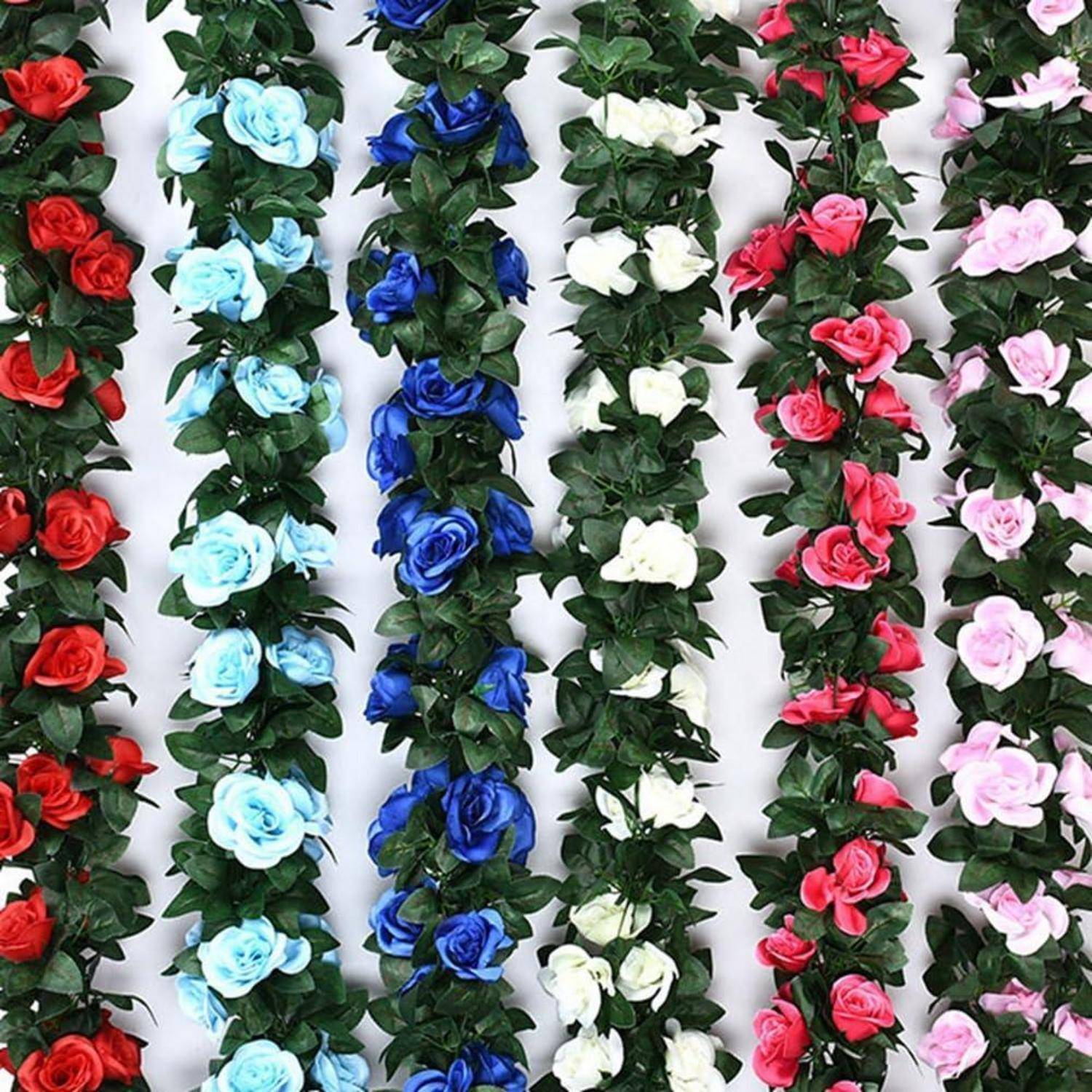 Vertikale Reihen von künstlichen Rosengirlandinen in Rot, Hellblau, Dunkelblau, Weiß, Rosa und Blassrosa vor weißem Hintergrund.