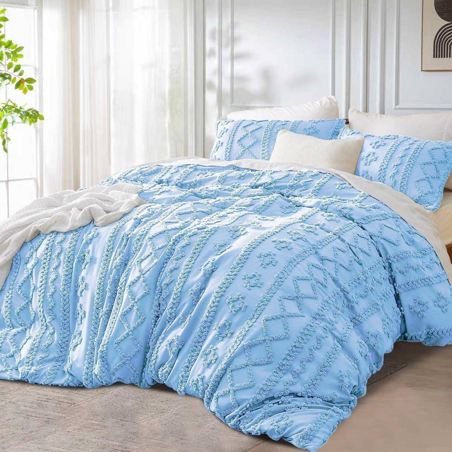 Eine hellblaue strukturierte Bettdecke und Kissenbezüge auf einem ordentlich gemachten Bett in einem hellen, minimalistischen Schlafzimmer.