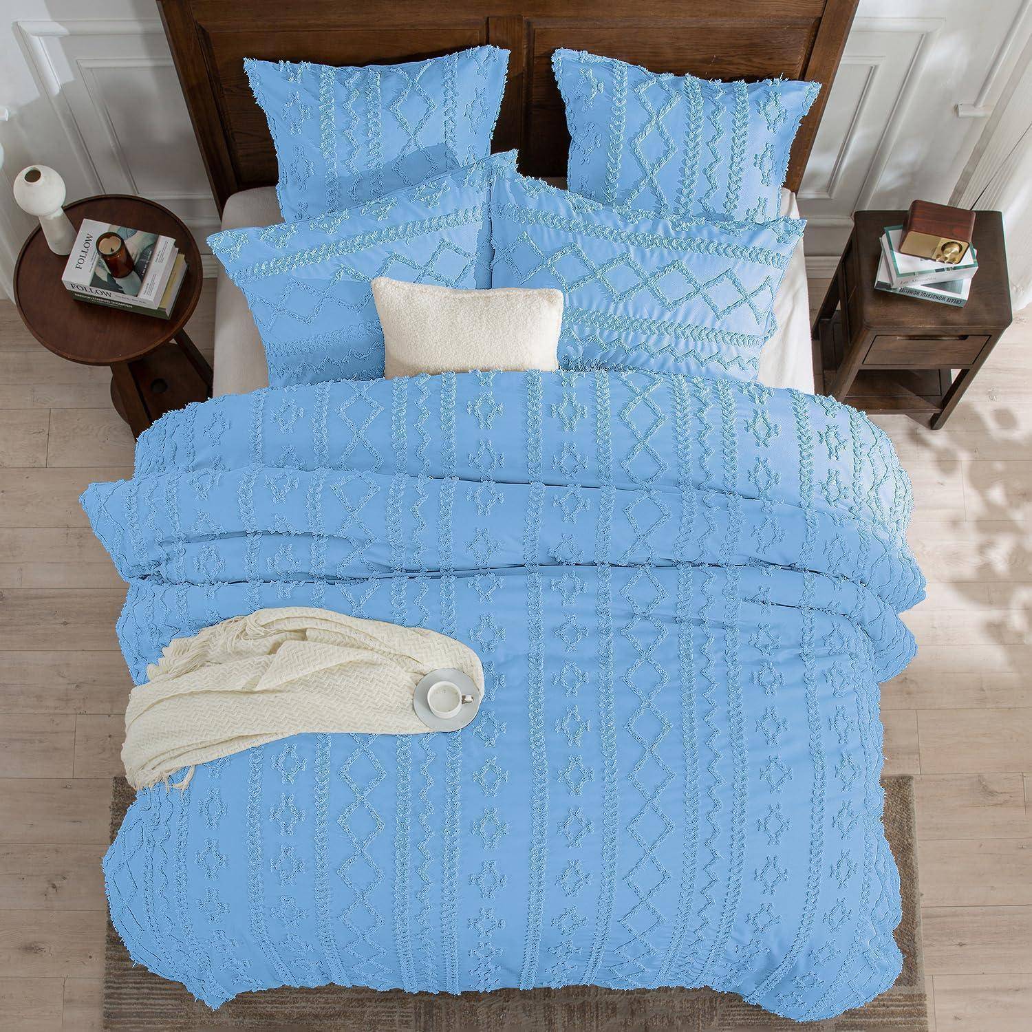 Blaugetupfter Bettwäscheset auf einem ordentlich gemachten Bett mit Kissen, weißem Akzentkissen, cremefarbener Wurfdecke und Nachttischen in einem Schlafzimmer.