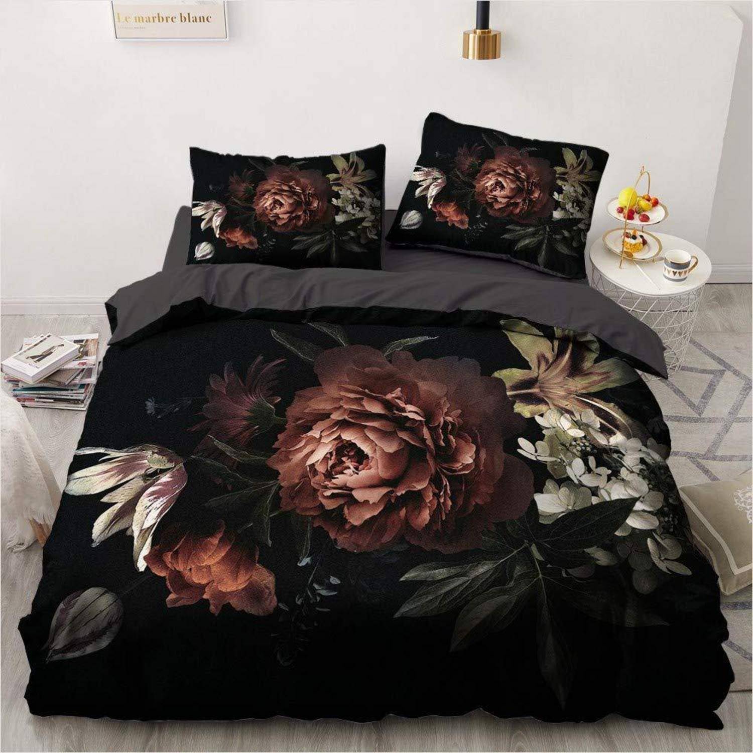 Schwarze Bettwäscheset mit Blumenmuster und großem dunkelrotem Rosendruck auf der Bettdecke und passenden Kissenbezügen in einem minimalistischen Schlafzimmer.