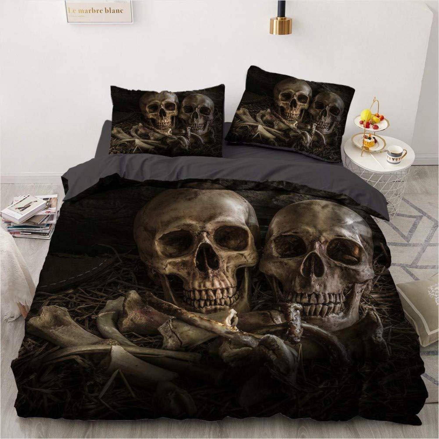 Bettwäsche-Set mit Totenkopf- und Knochenmuster in einem Schlafzimmer, das eine dunkle gotische Bettdecke und passende Kissenbezüge mit zwei großen Schädeln auf der Vorderseite zeigt.