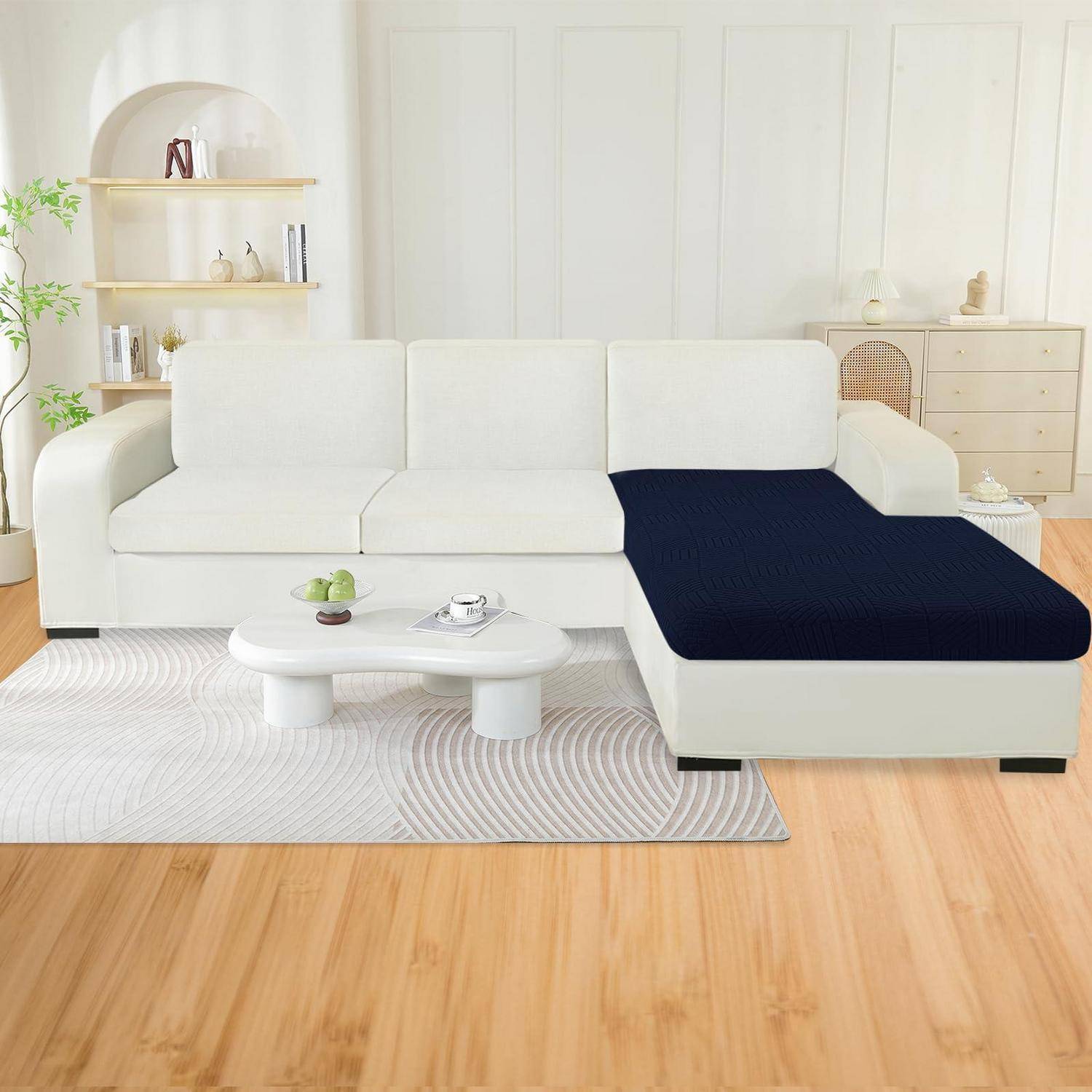 Weiße L-förmige Eckcouch mit einer dunkelblauen Chaiselongue in einem hellen Wohnzimmer, mit einem Couchtisch, Regalen und einer Kommode.