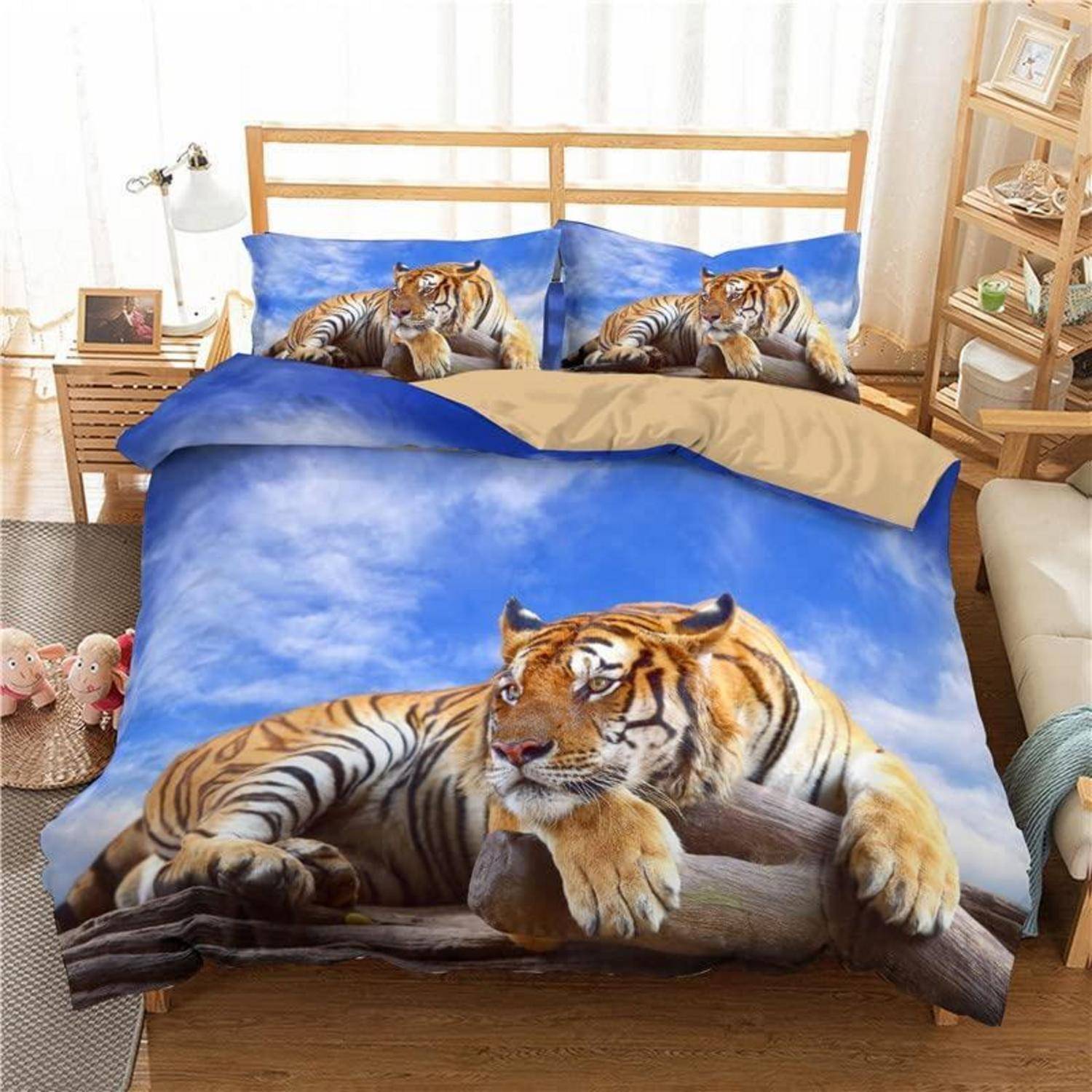 Bett mit Tiger-Muster-Bettwäsche und Kissen mit einem liegenden Tiger auf blauem Himmelshintergrund in einem hellen Schlafzimmer.