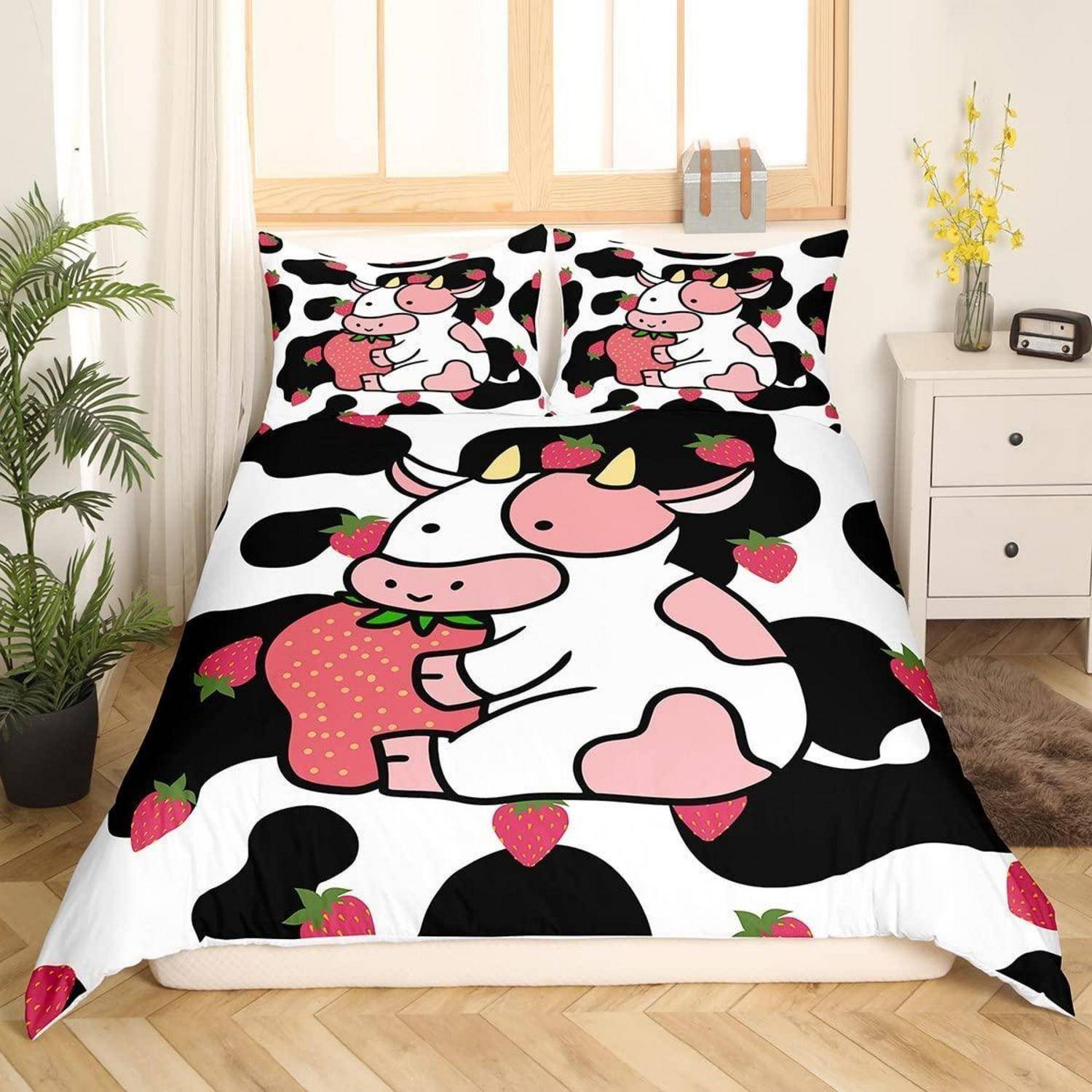 Bett mit Kuhflecken-Bettwäsche mit einer Cartoon-Kuh, die eine große Erdbeere umarmt, in einem hellen Schlafzimmer neben einem Nachttisch und Pflanzen.