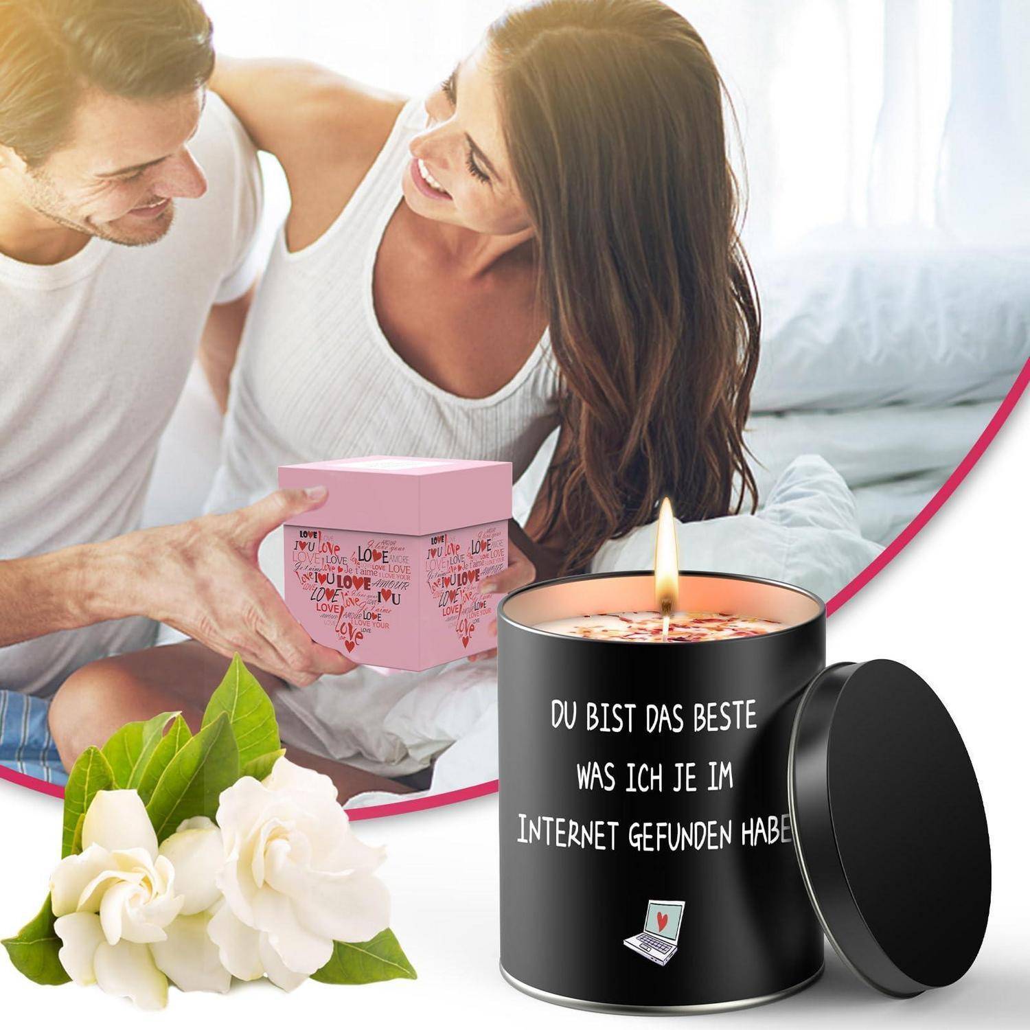 Romantische Geschenkszene: lachendes Paar auf einem Bett mit einer rosa Geschenkbox und weißen Rosen neben einer brennenden schwarzen Kerze, beschriftet auf Deutsch: „Du bist das Beste, das ich je im Internet gefunden habe".