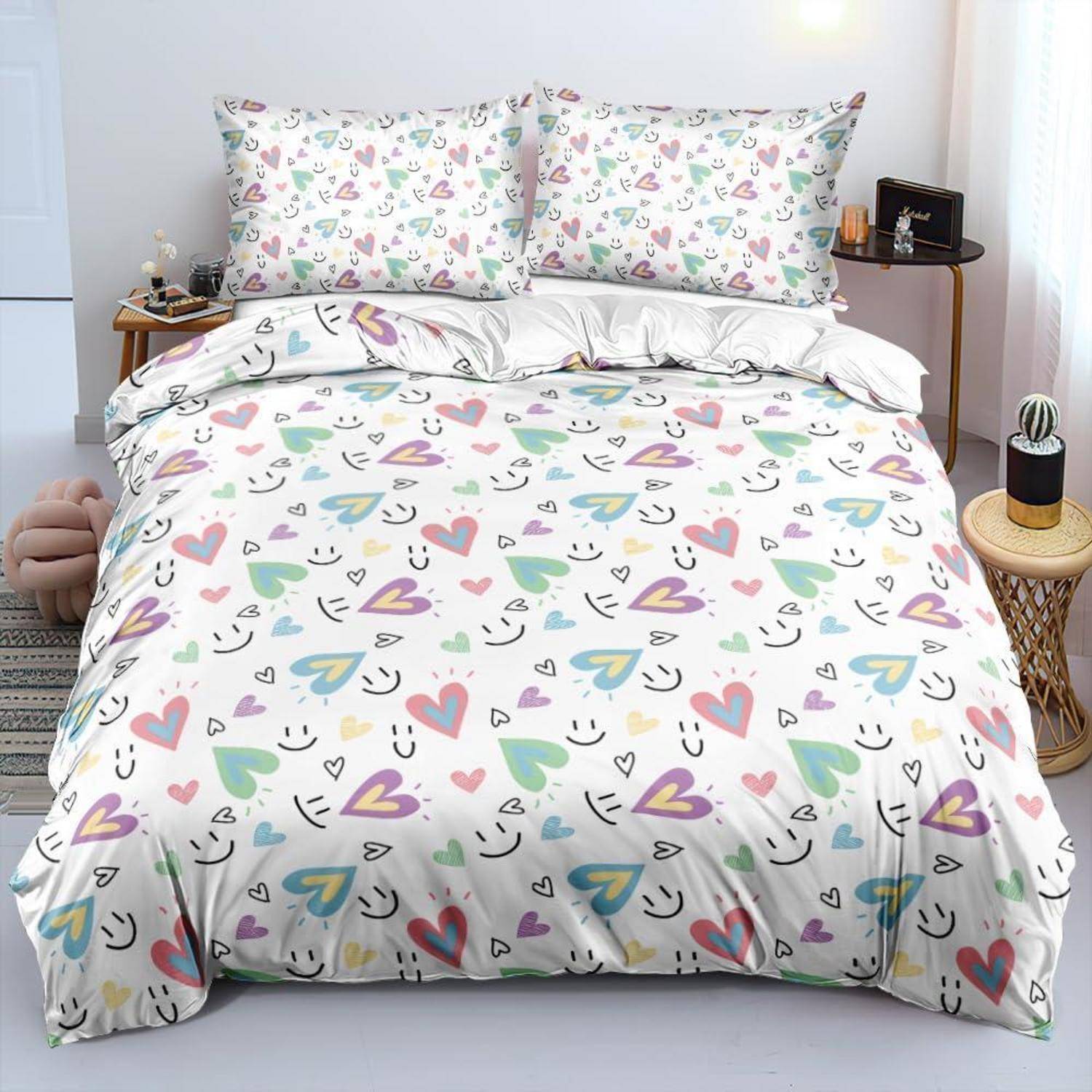 Bett mit weiß gemusterter Herzdecke und passenden Kissenbezügen in Pastellfarben, gezeigt in einer ordentlichen Schlafzimmereinrichtung.