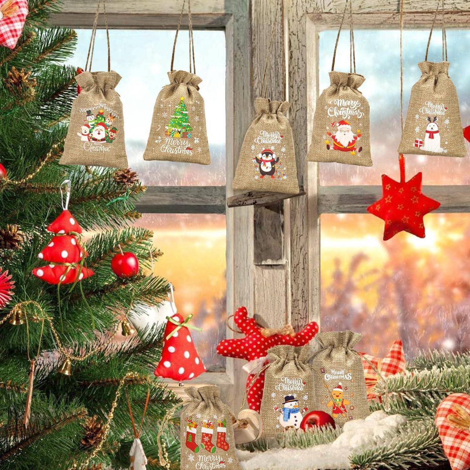Weihnachtsdekorationen mit Jutesäcken als Geschenkbeutel, die an einem Fenster hängen, neben einem geschmückten Nadelbaum und roten Verzierungen in einer gemütlichen Weihnachtsszenerie.