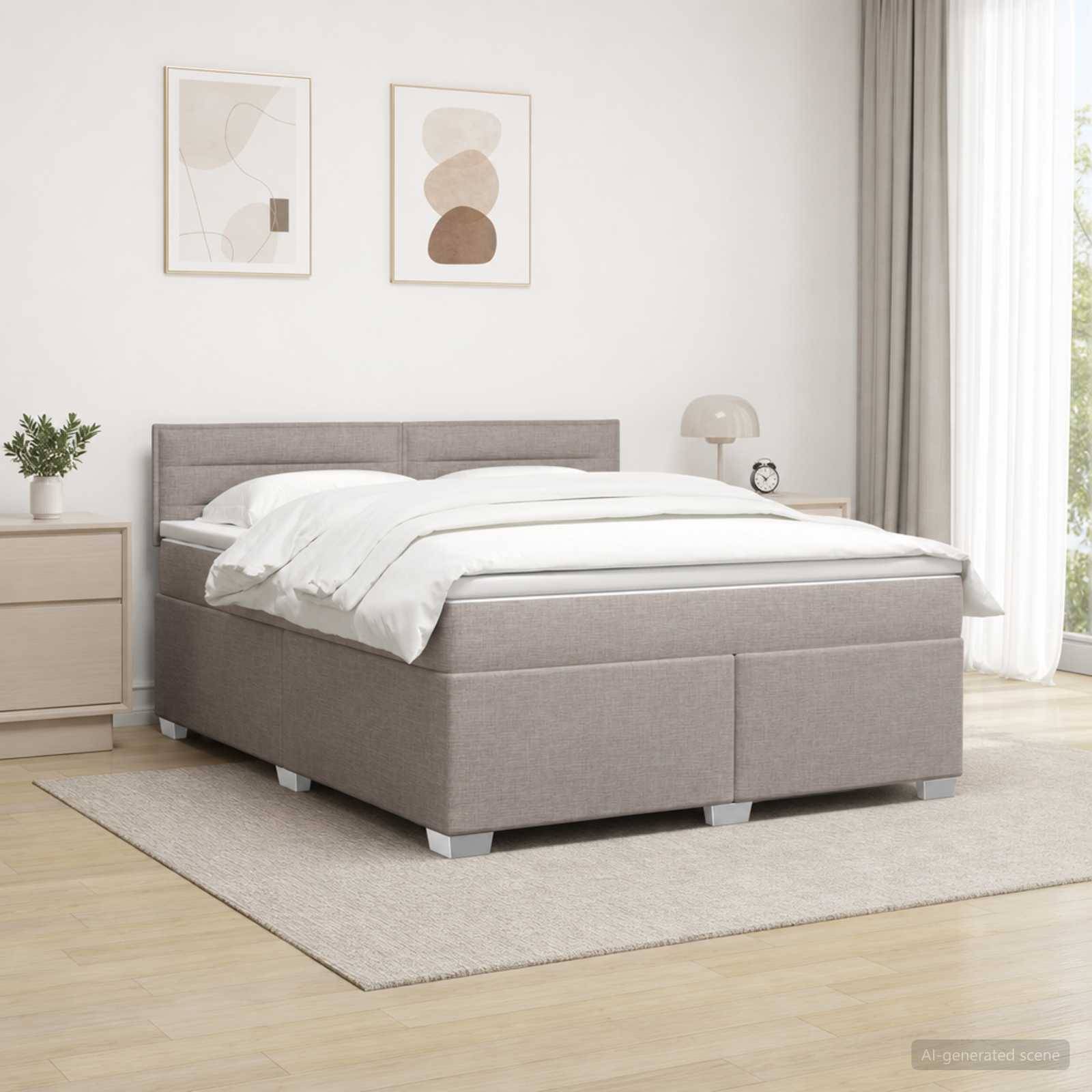Ein ordentlich gemachtes grau gepolstertes Bett in einem hellen, minimalistischen Schlafzimmer mit Nachttisch, Lampe, Bilderrahmen und einem Teppich.