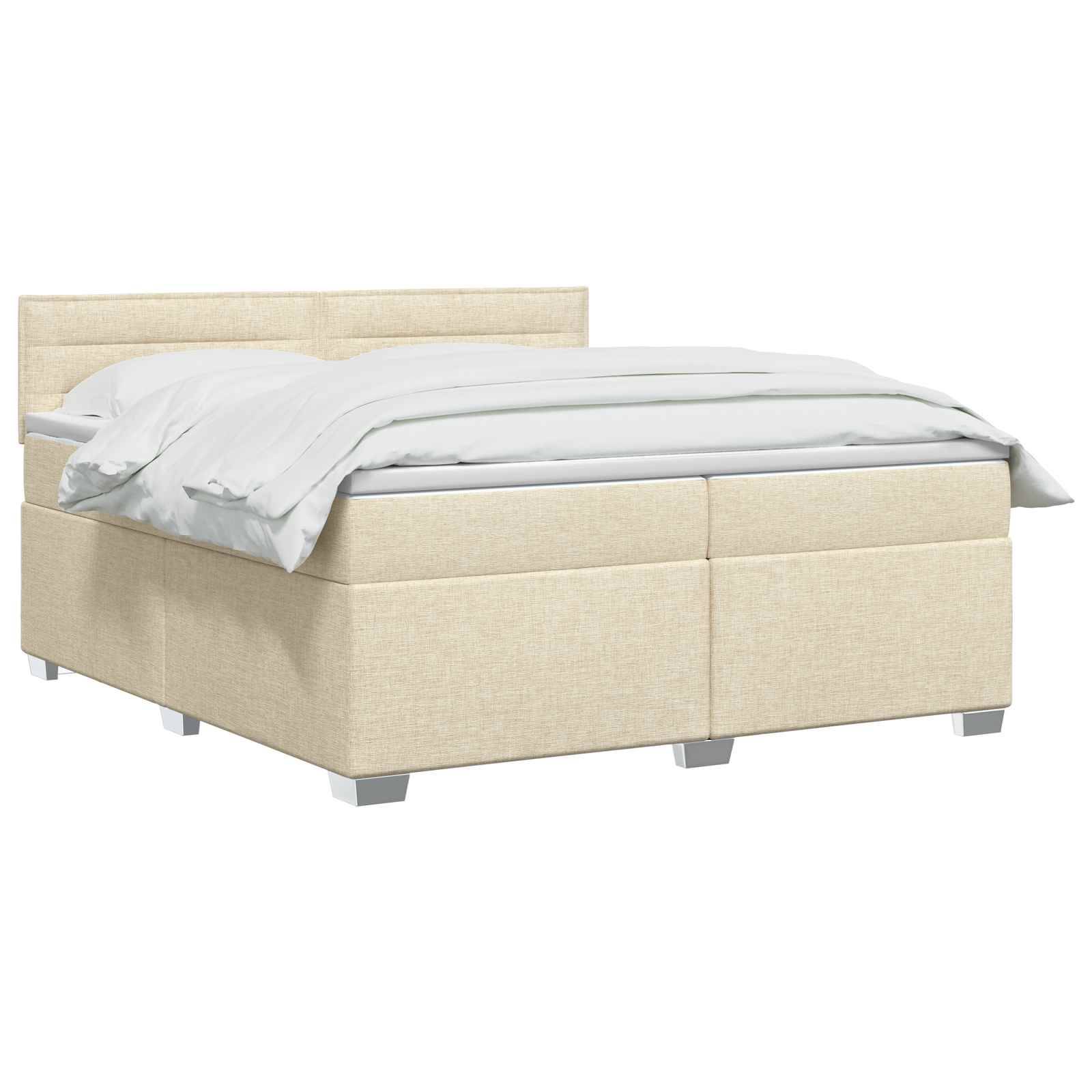 Beige gepolstertes Speicherbett mit Kopfteil, weiße Bettwäsche und kastenförmige Basis auf kurzen Beinen.