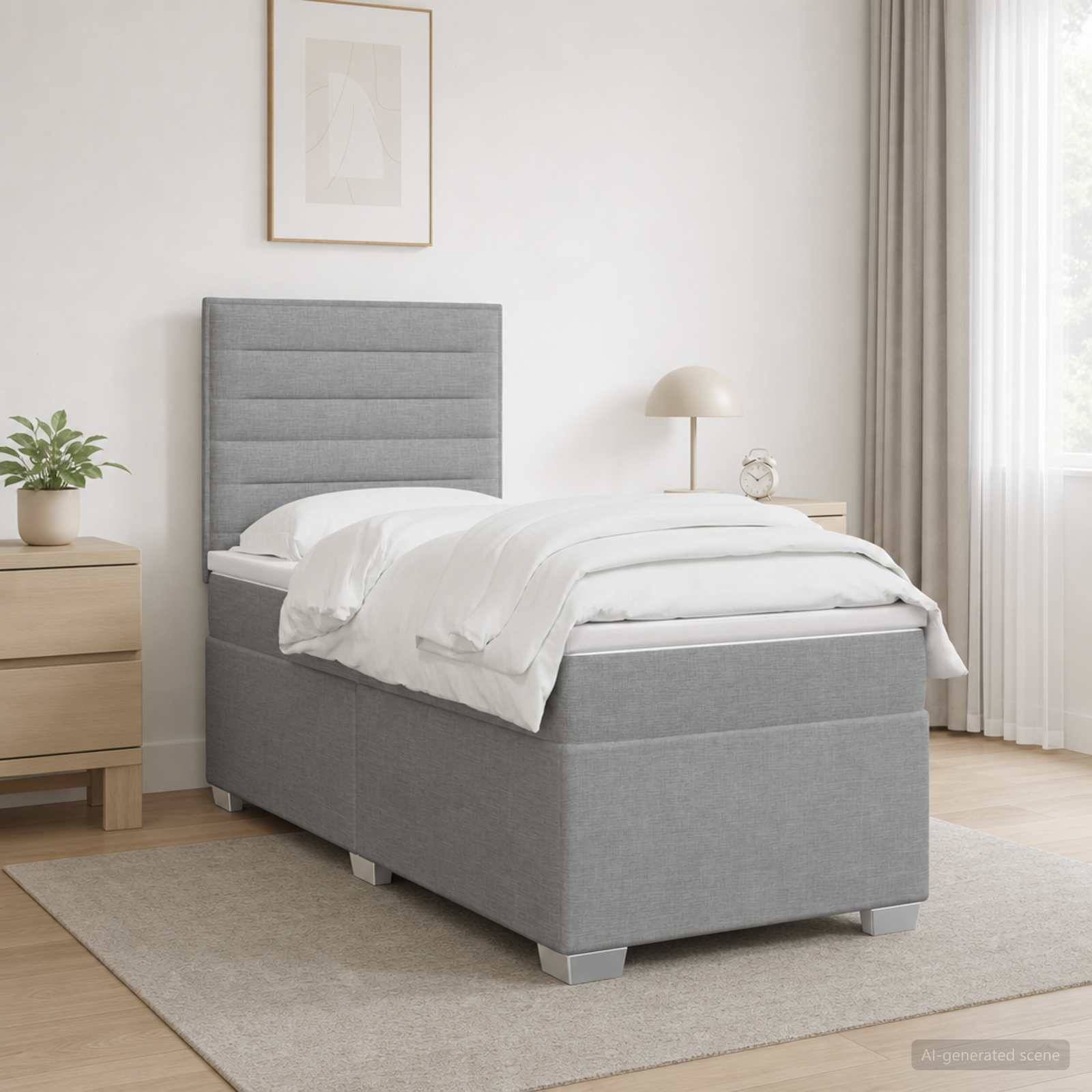 Minimalistisches Schlafzimmer mit einem grau gepolsterten Einzelbett, weißer Bettwäsche, Nachttisch mit Lampe, Pflanze, gerahmtem Wandbild und Fenstervorhängen.