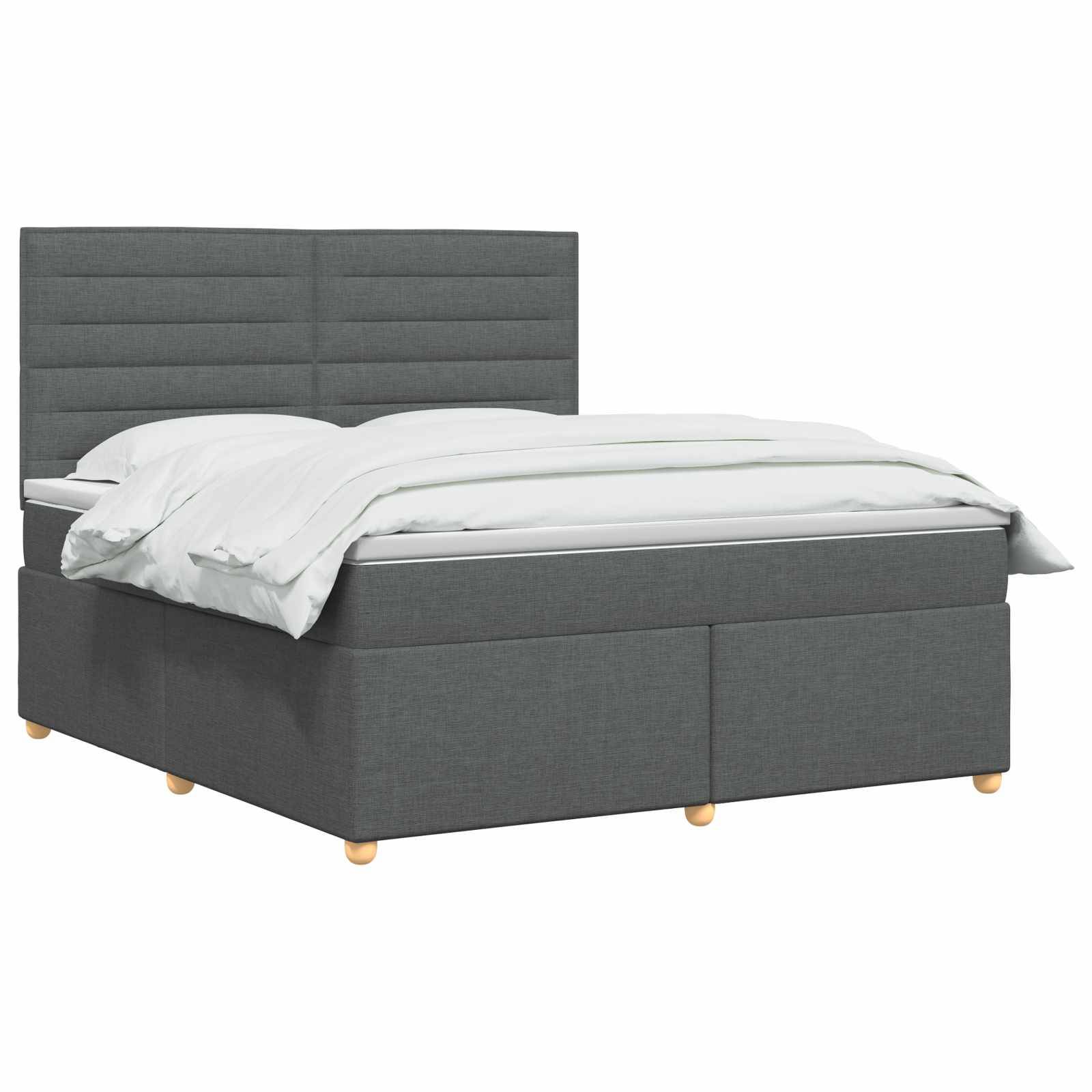 Grau gepolstertes Bett mit gepolstertem Kopfteil, weiße Bettwäsche und helle Holzfüße auf einfachem weißem Hintergrund.