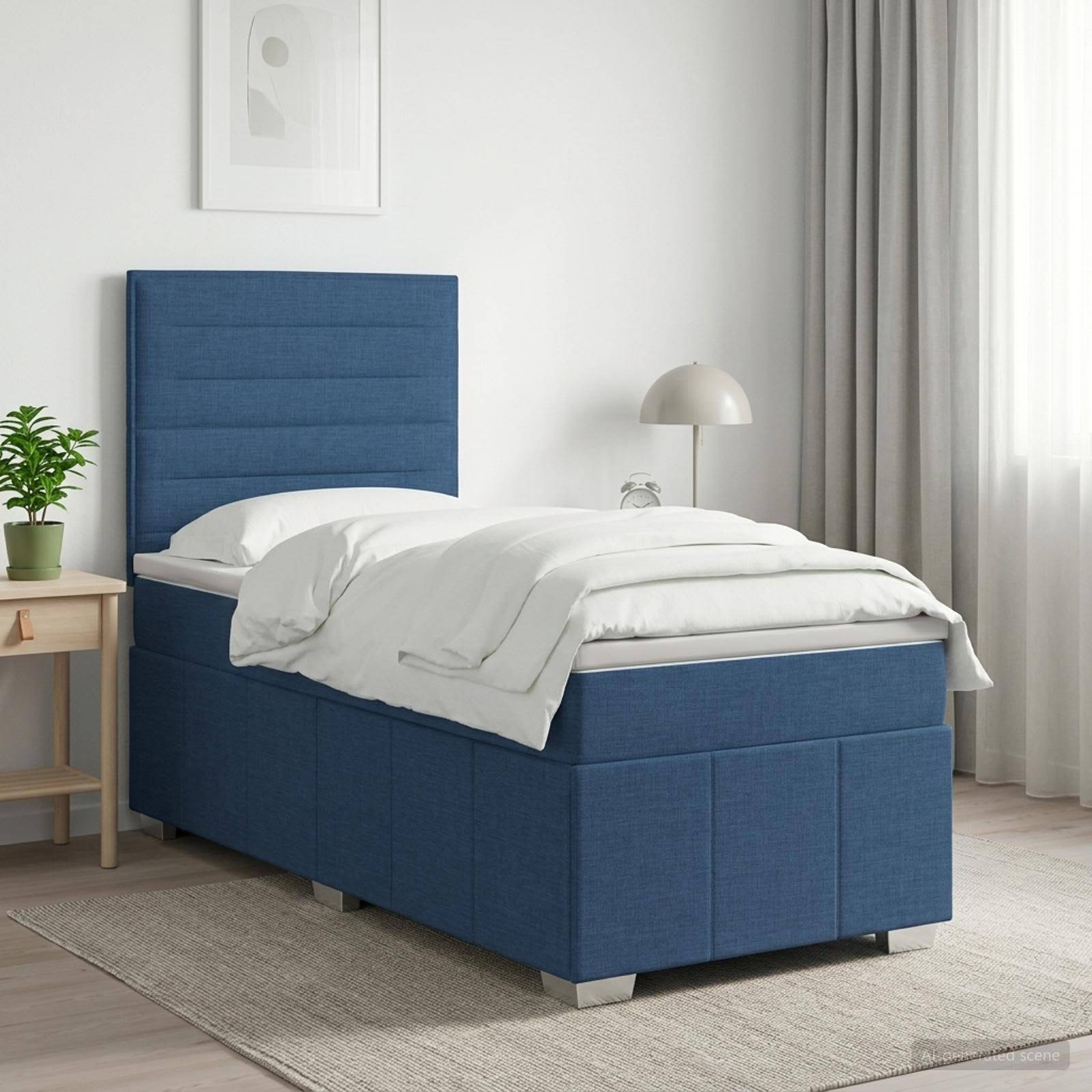 Blaugepolstertes Einzelbett mit weißer Bettwäsche in einem hellen, minimalistischen Schlafzimmer neben einem Nachttisch, einer Lampe und Fenstergardinen.