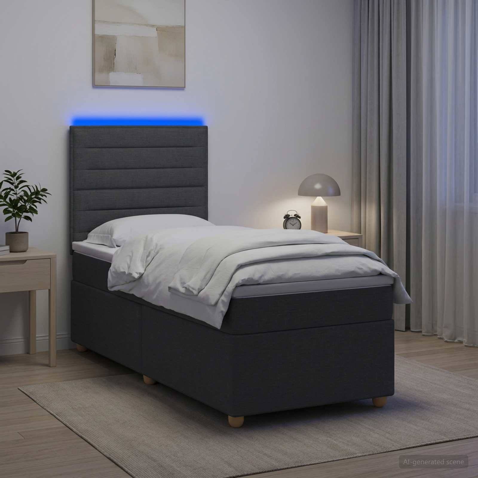 Modernes Einzelbett mit grauem gepolstertem Kopfteil und blauem LED-Streifen in einem minimalistischen Schlafzimmer neben einem Nachttisch und einer Lampe.