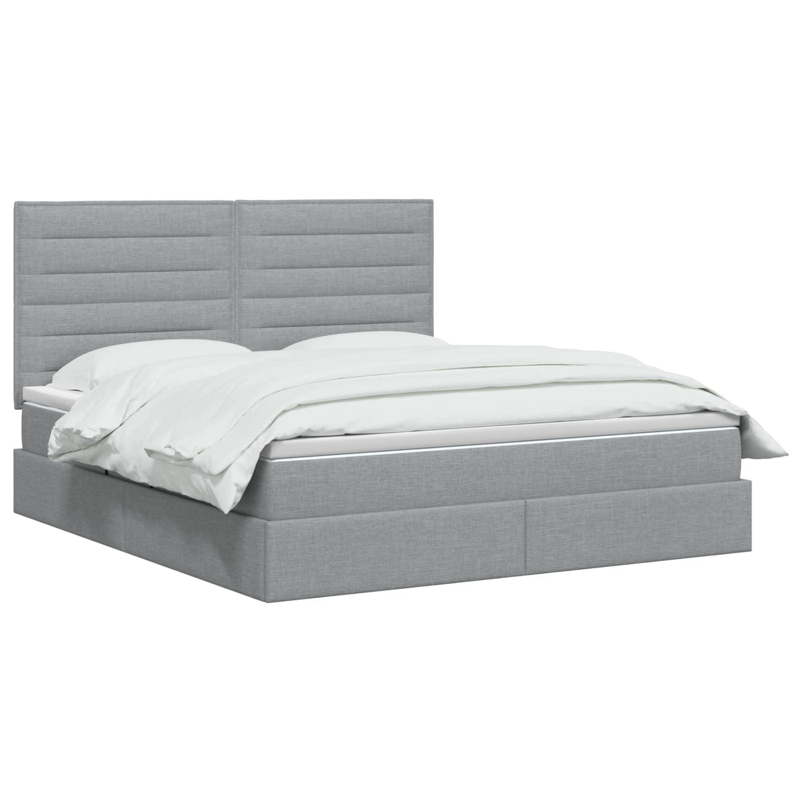 Grau gepolstertes Bett mit Kopfteil mit Paneelen und weißer Bettwäsche auf einfachem weißem Hintergrund.