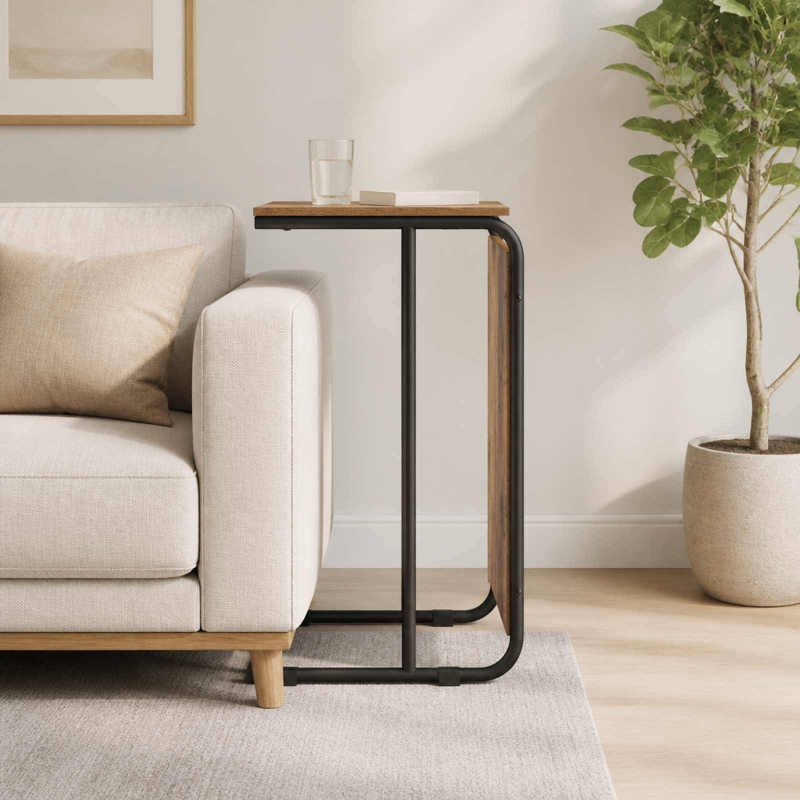 Minimalistisches Wohnzimmer mit beigem Sofa, schmalem Beistelltisch, Glas und Topfbaum auf hellem Teppich und Holzboden.