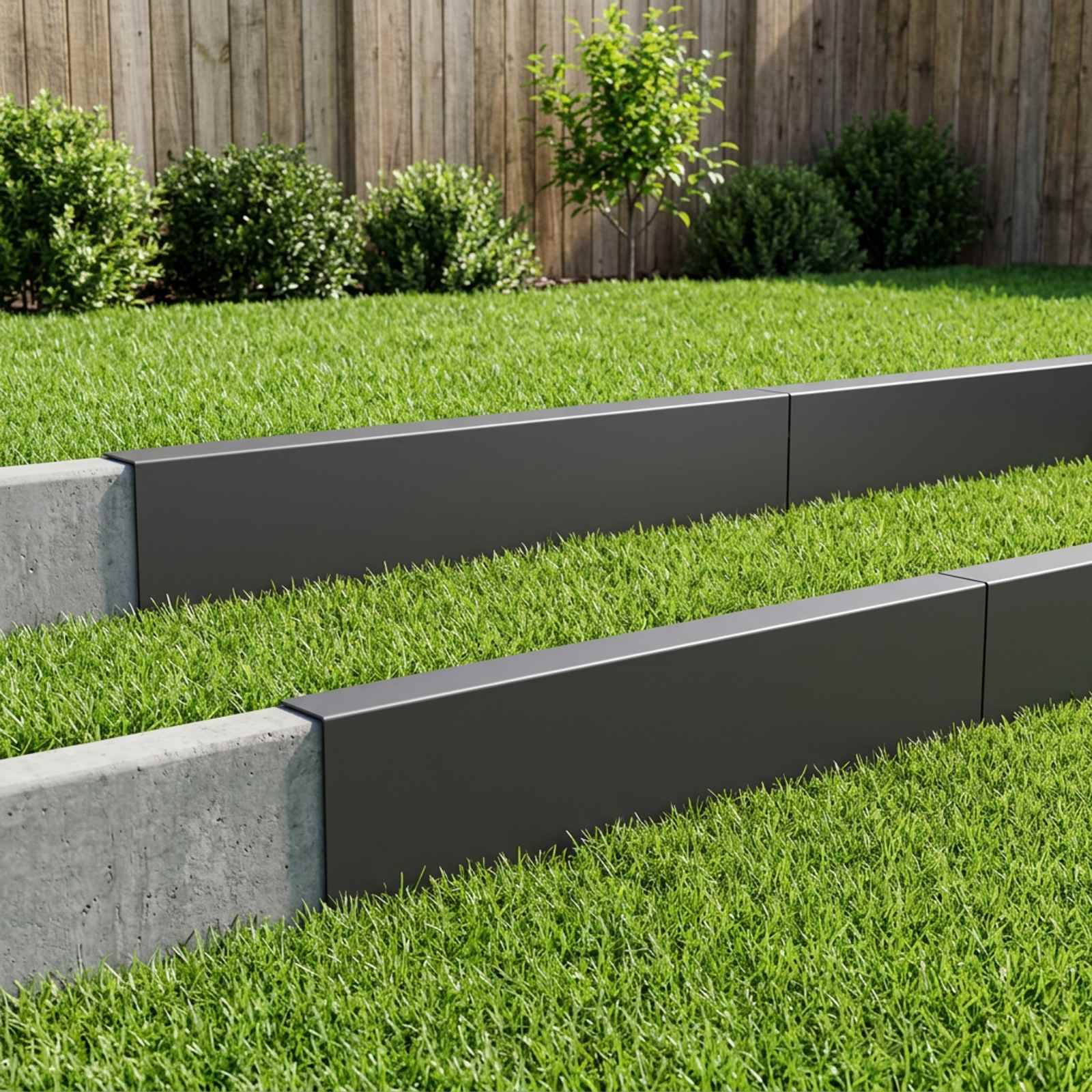 Moderner gestalteter Hof mit zwei langen erhöhten Pflanzbeeten oder Stützmauerkanten aus grauem Beton und dunklen Paneelen neben einem grünen Rasen und einem Holzzaun.