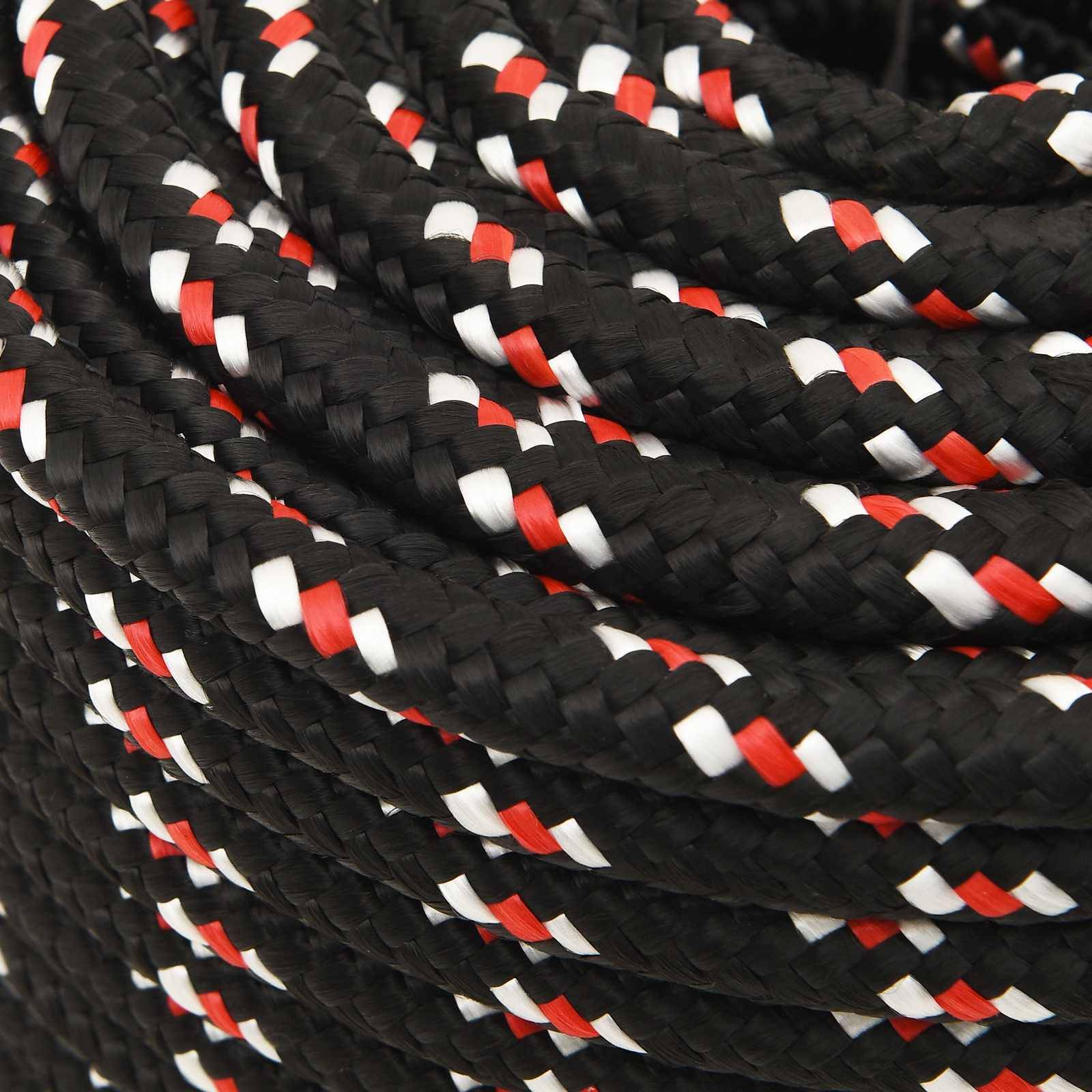 Nahaufnahme eines eng aufgerollten schwarzen geflochtenen Seils mit roten und weißen Flöckchen.
